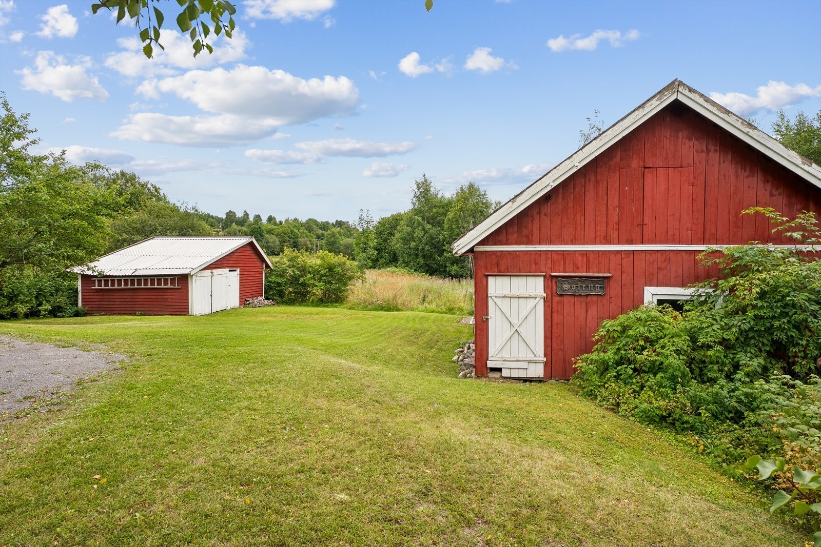 Usjenert, skrånende tomt på 1220 m² med enebolig, låve og garasje/uthus. Galleribilde