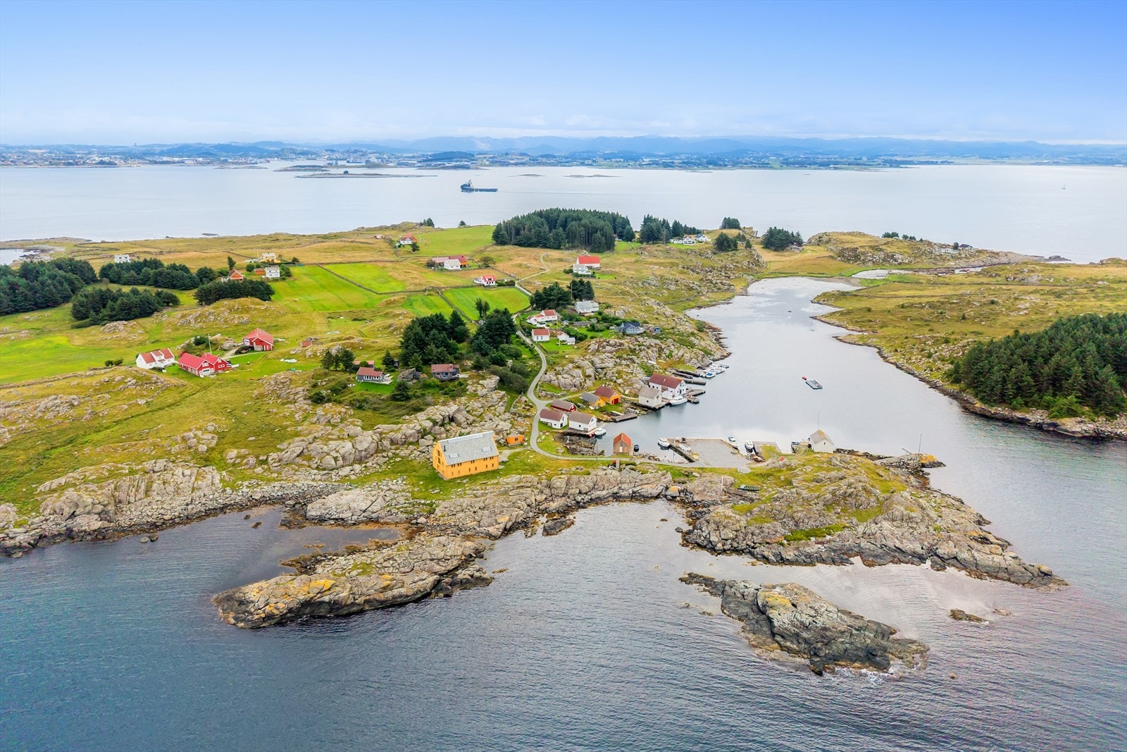 Oversikt over hele øya, som viser en blanding av bebyggelse, skog og dyrket mark. Galleribilde