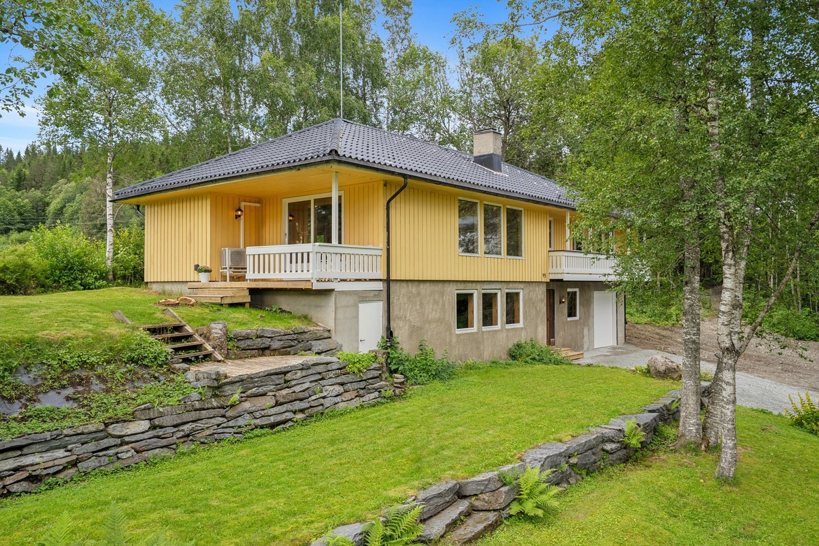 Boligen ligger pent til på tomten med opparbeidede grøntarealer. Galleribilde