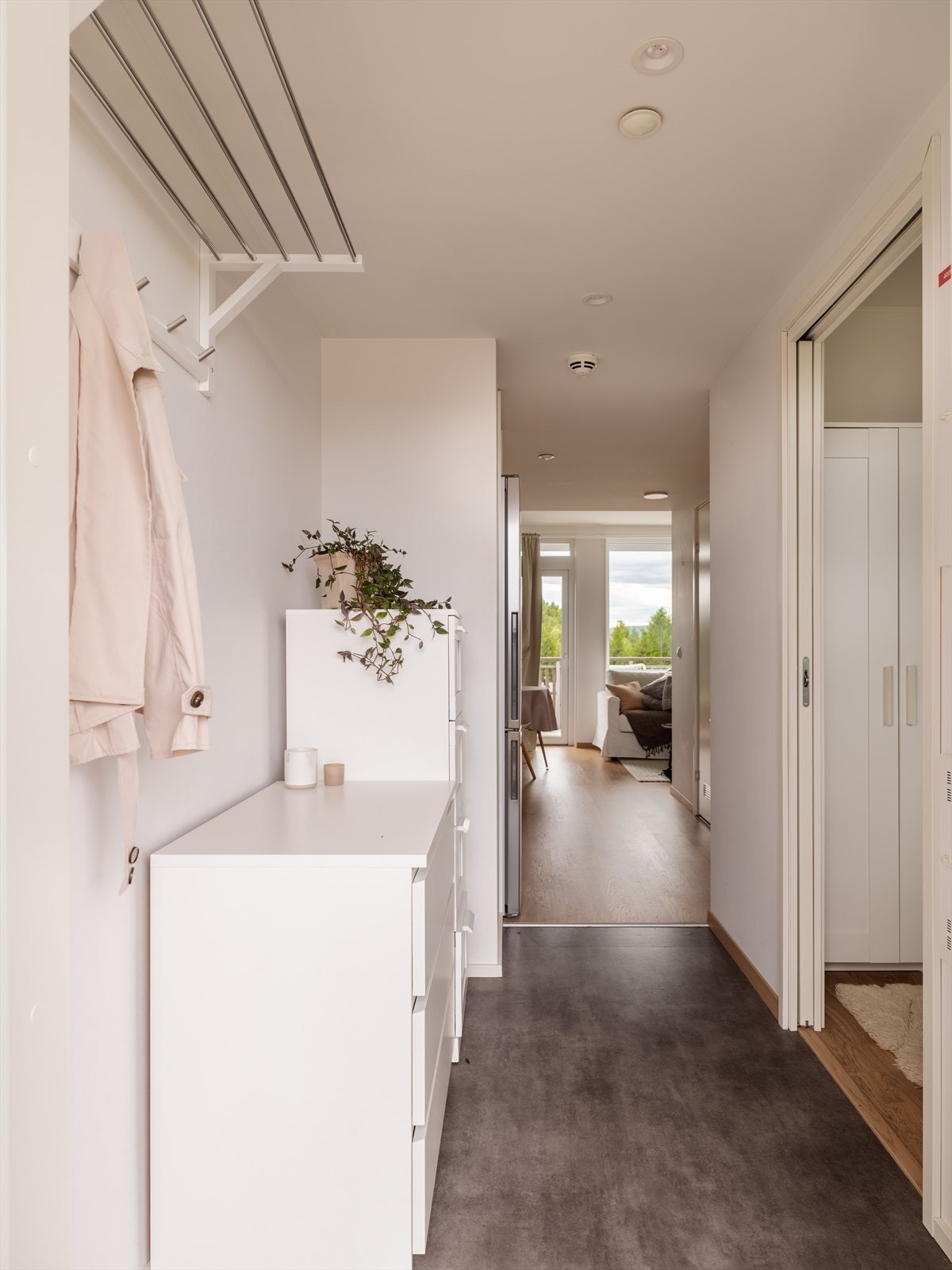 Leiligheten har en lys og innbydende entré med lysmalte vegger og parkett på gulv. Galleribilde