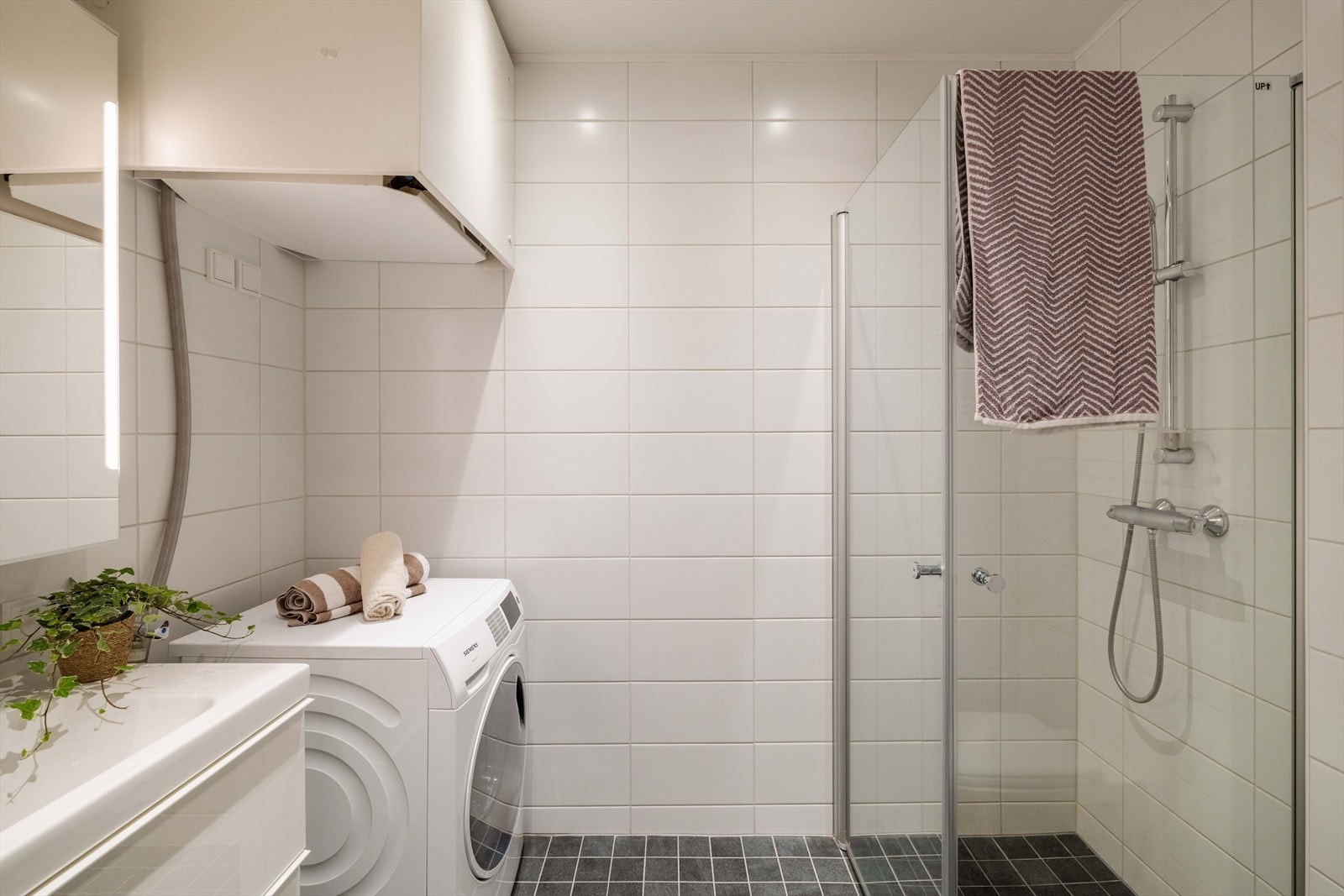 Pent, helfliset baderom med gulvvarme. Badet er innredet med servant, klosett og dusjhjørne med innfellbare glassdører. Galleribilde