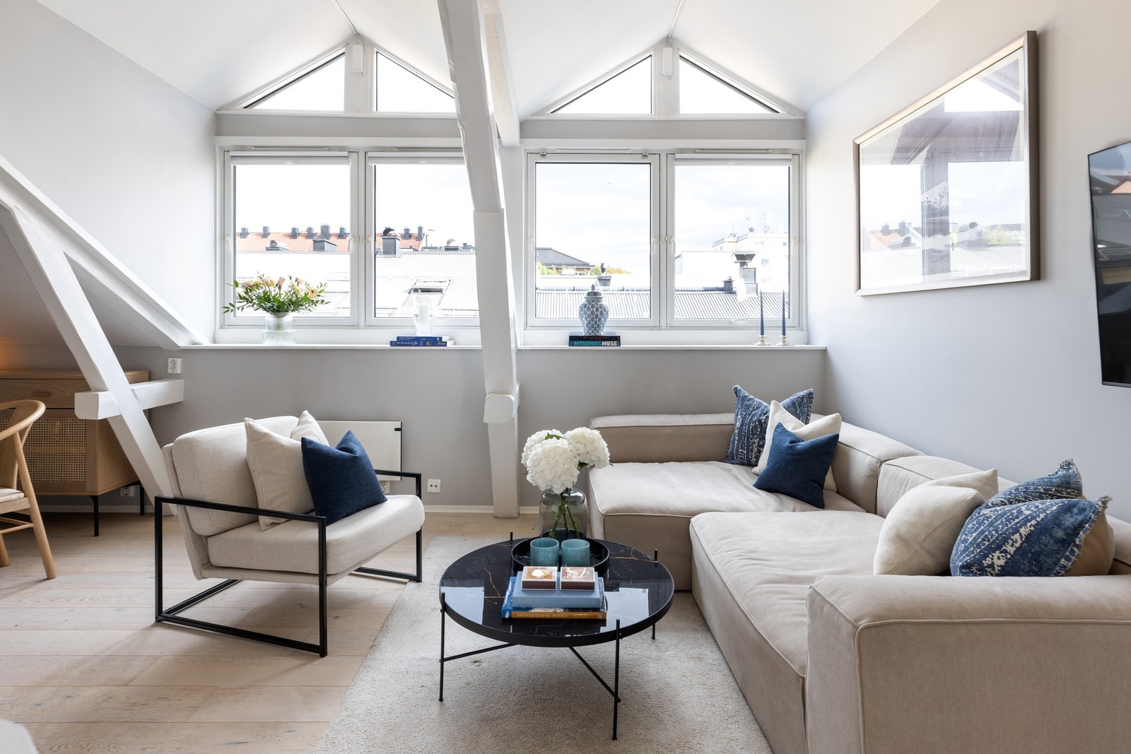 Store vindusflater slipper inn rikelig med naturlig lys og gir stuen en lys og luftig atmosfære Galleribilde