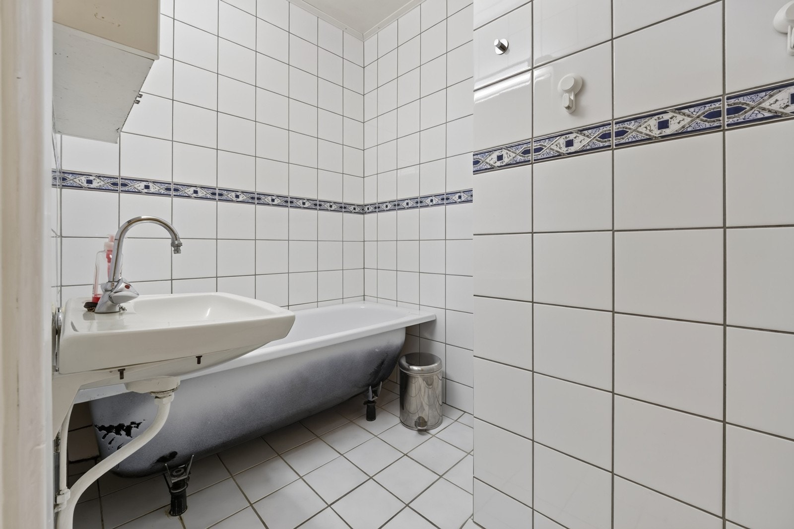 Bad med flislagte overflater, servant og badekar. Galleribilde