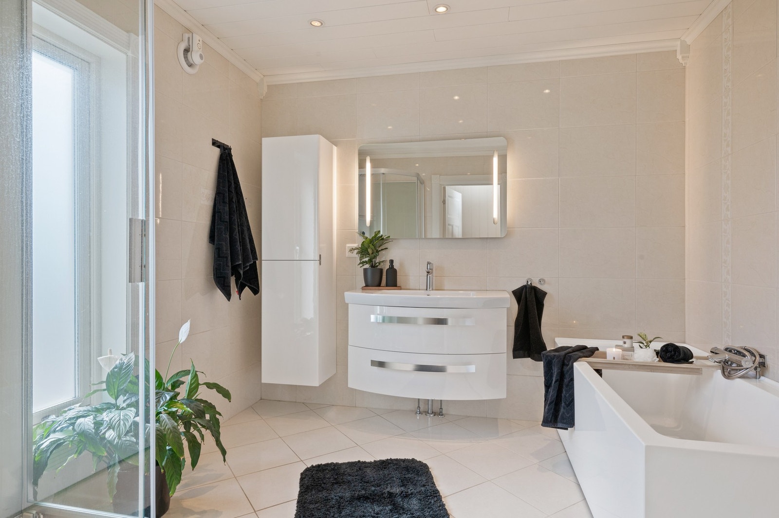 Badet har keramiske fliser på vegger og gulv, samt malt plate i tak. Galleribilde