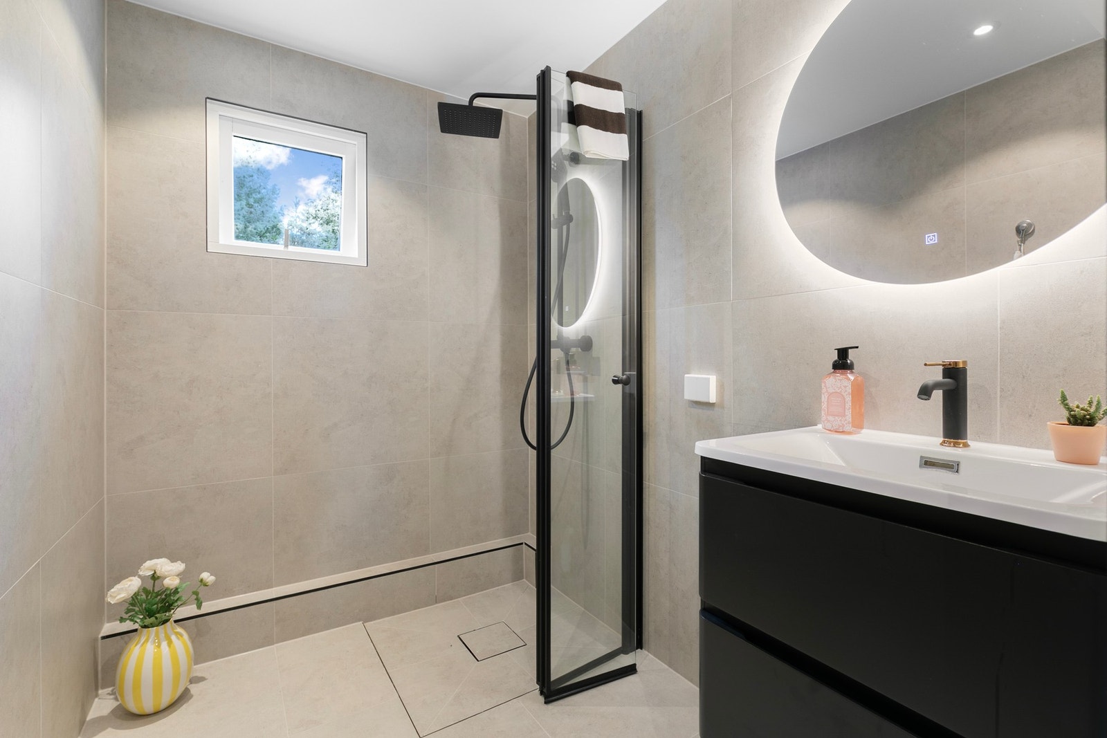 Badet har praktisk dusjløsning og en flott, moderne fargepalett. Galleribilde