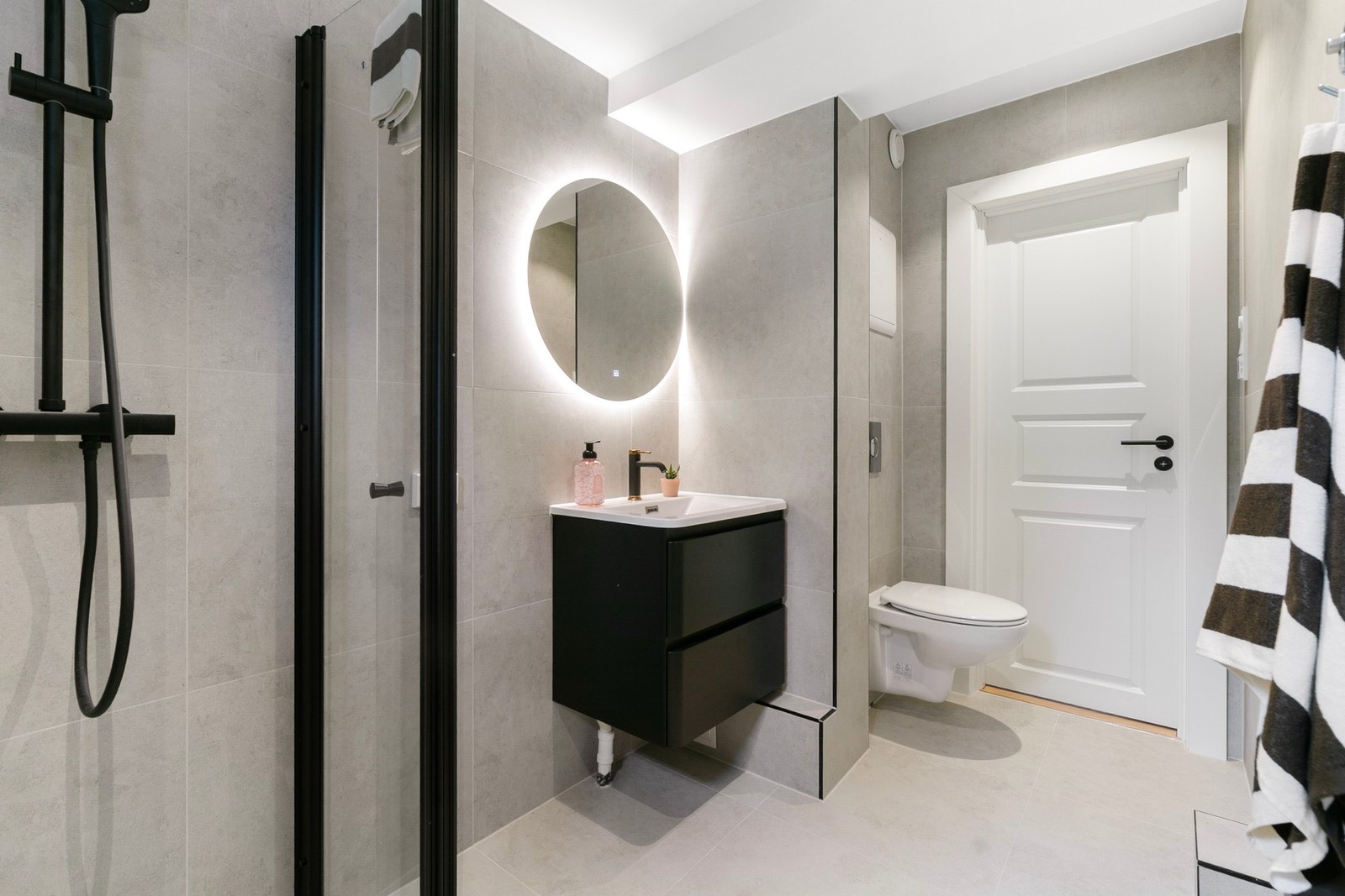 Moderne bad med stilrene detaljer og fint speil med integrert belysning. Galleribilde