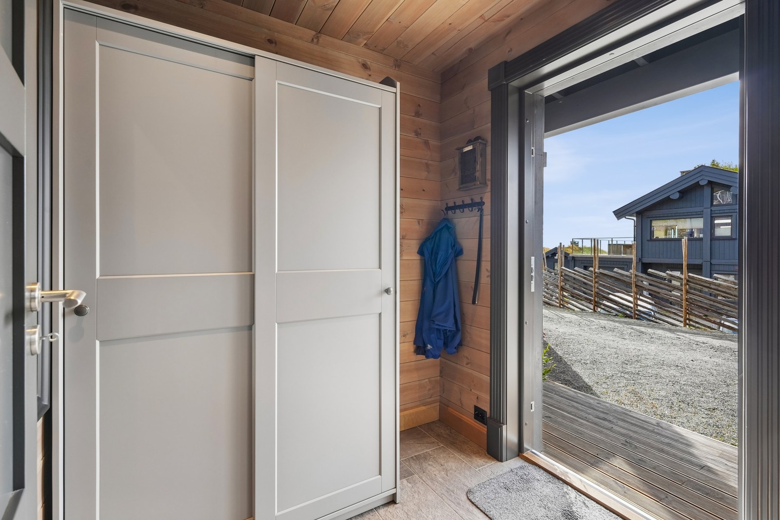 Entréen har flislagt gulv og vegger kledd i liggende panel.
Skyvedørsgarderobe. Galleribilde