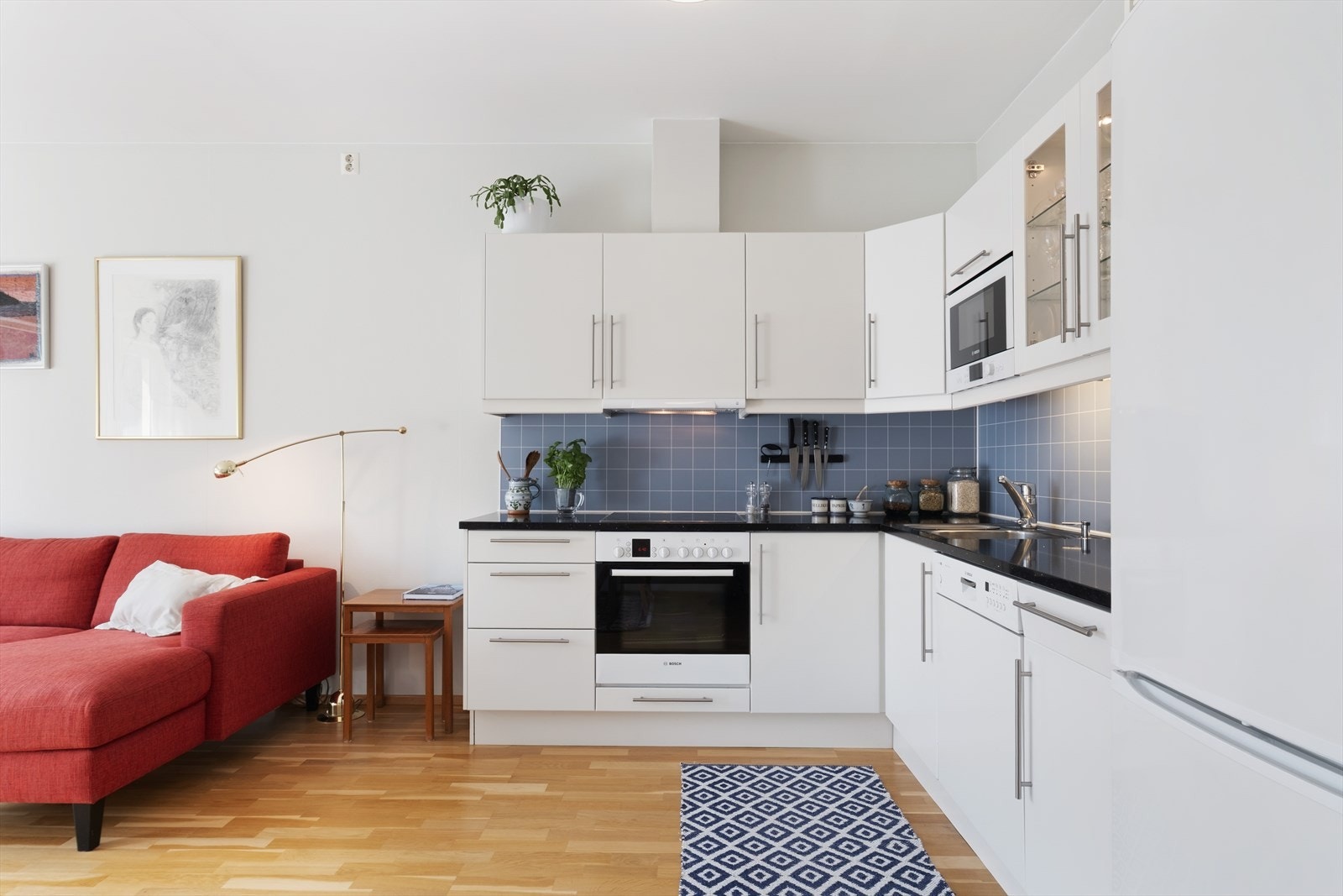 Tidlaust kjøkken med kvite slette fronter og påkosta benkeplate i dekorativ steinutførelse. Kjøkkenet er godt utnytta og har god skåp- og benkeplass. Galleribilde