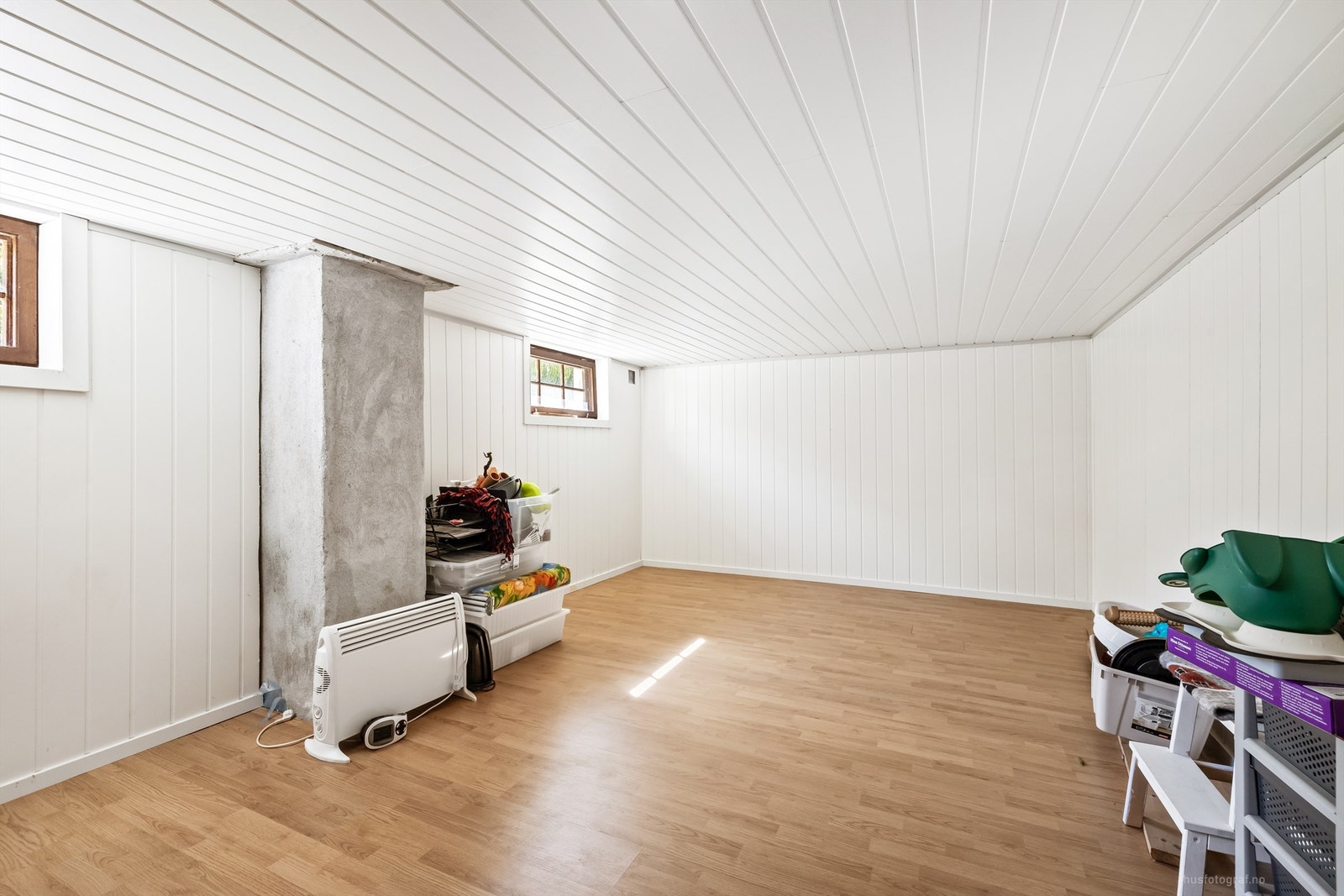 Innredet kjellerstue i kjelleren med laminatgulv og panelplater på veggene. Rommet er ikke byggemeldt. Galleribilde