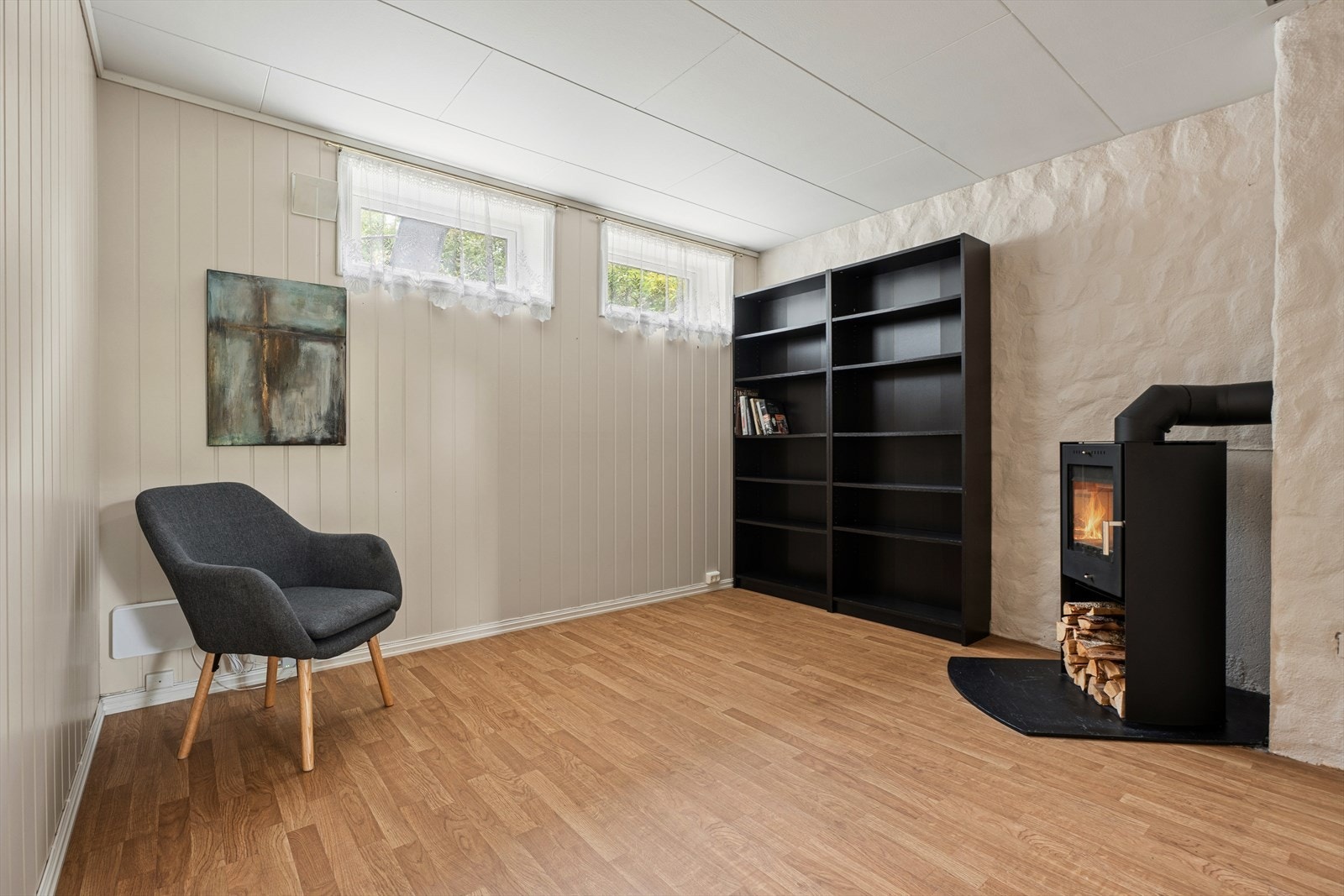 Kjellerstue med vedovn og gode innredningsmuligheter. Et ekstra oppholdsrom som passer godt som TV-stue, ungdomsstue eller hobbyrom. Galleribilde