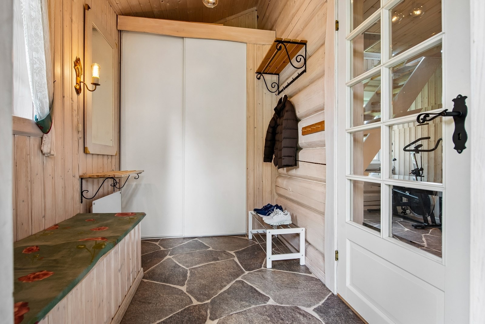 Entréen har god plass til oppbevaring i plassbygget garderobe. Skifermønstret gulvbelegg og trepanelte vegger. Galleribilde