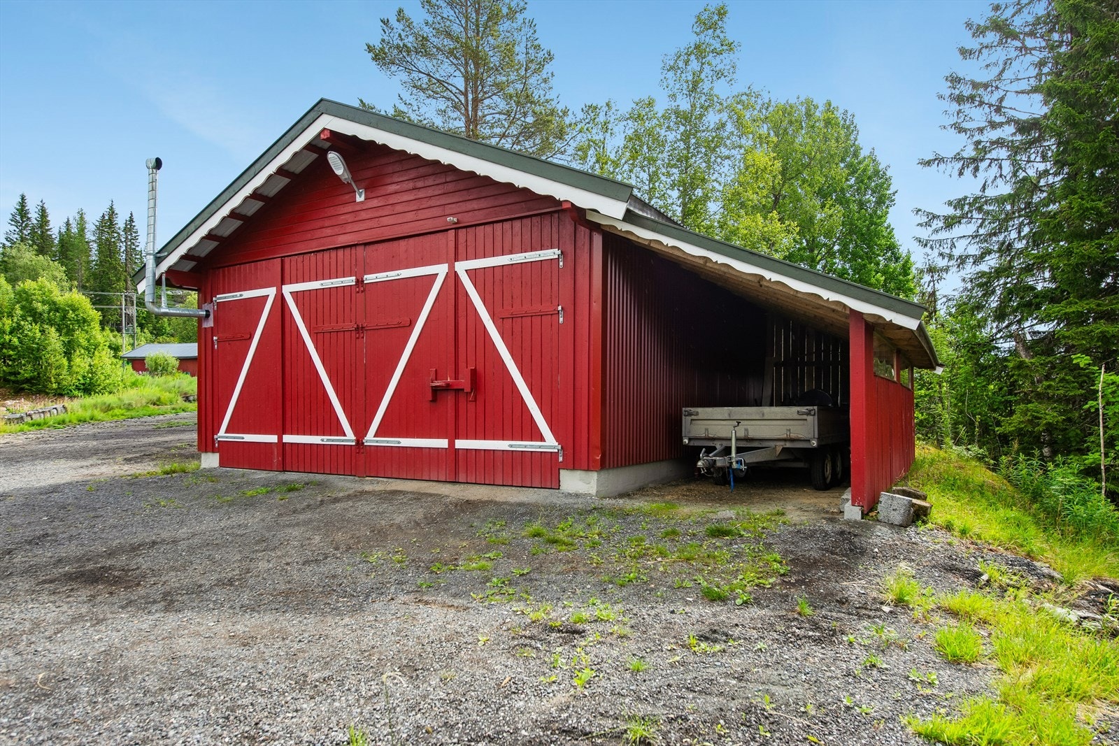 Romslig traktorgarasje og verksted på 46 m² med tilhørende carport, bygget i 2021. Galleribilde