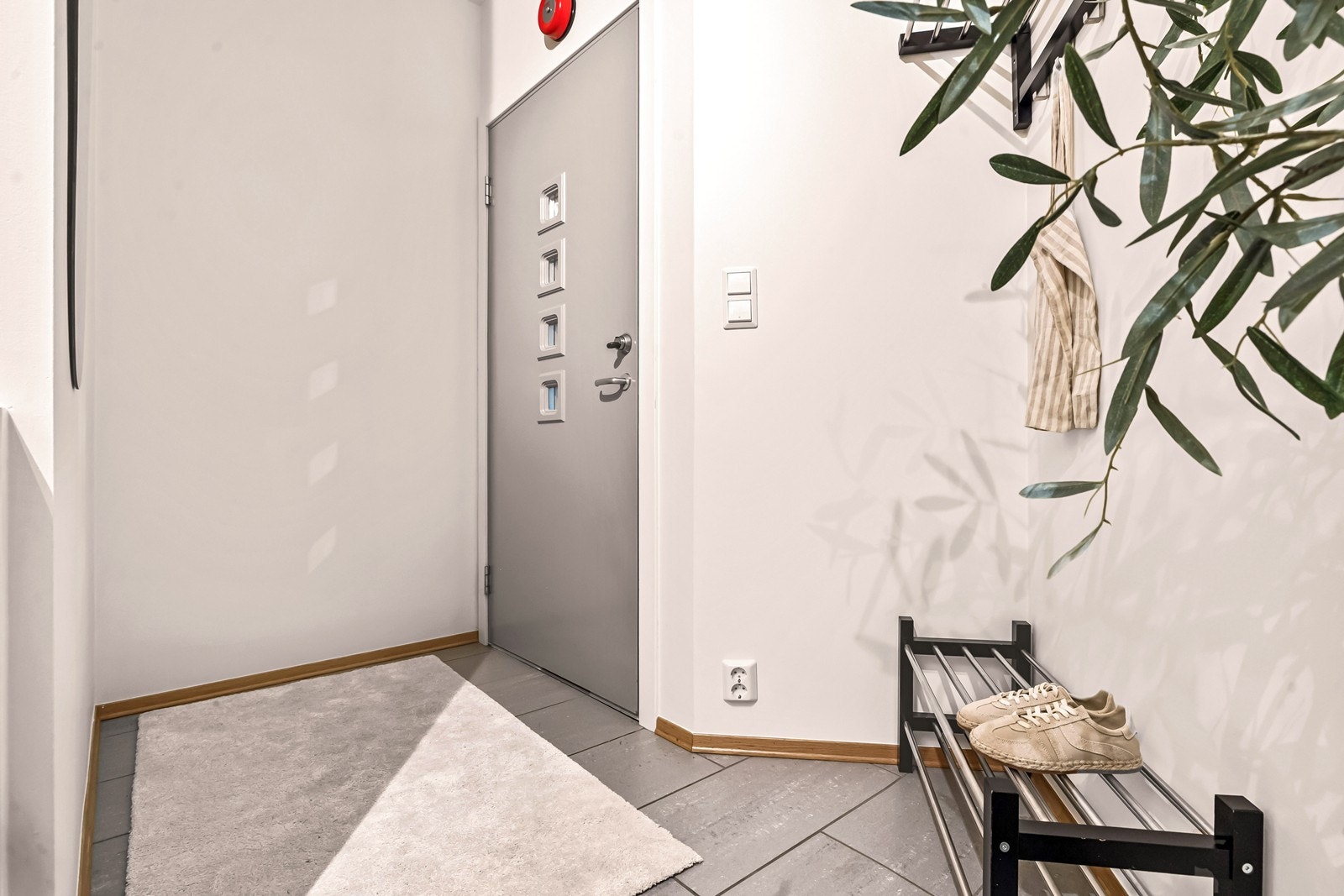 Entréen er innbydende med moderne overflater og plass for yttertøy og sko. Galleribilde