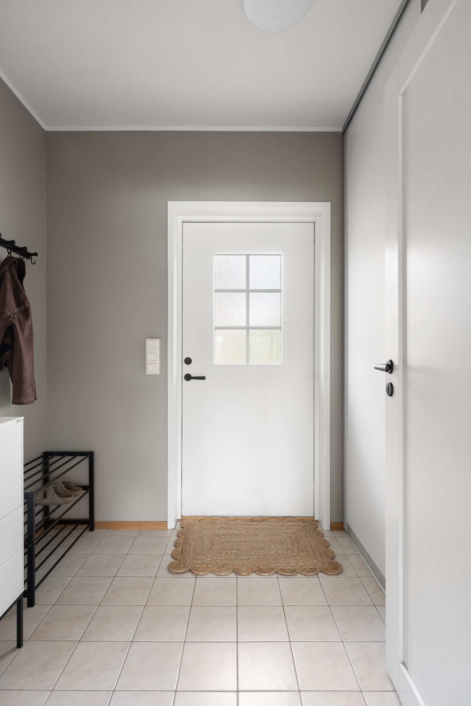 Romslig gang med skyvedørsgarderobe.