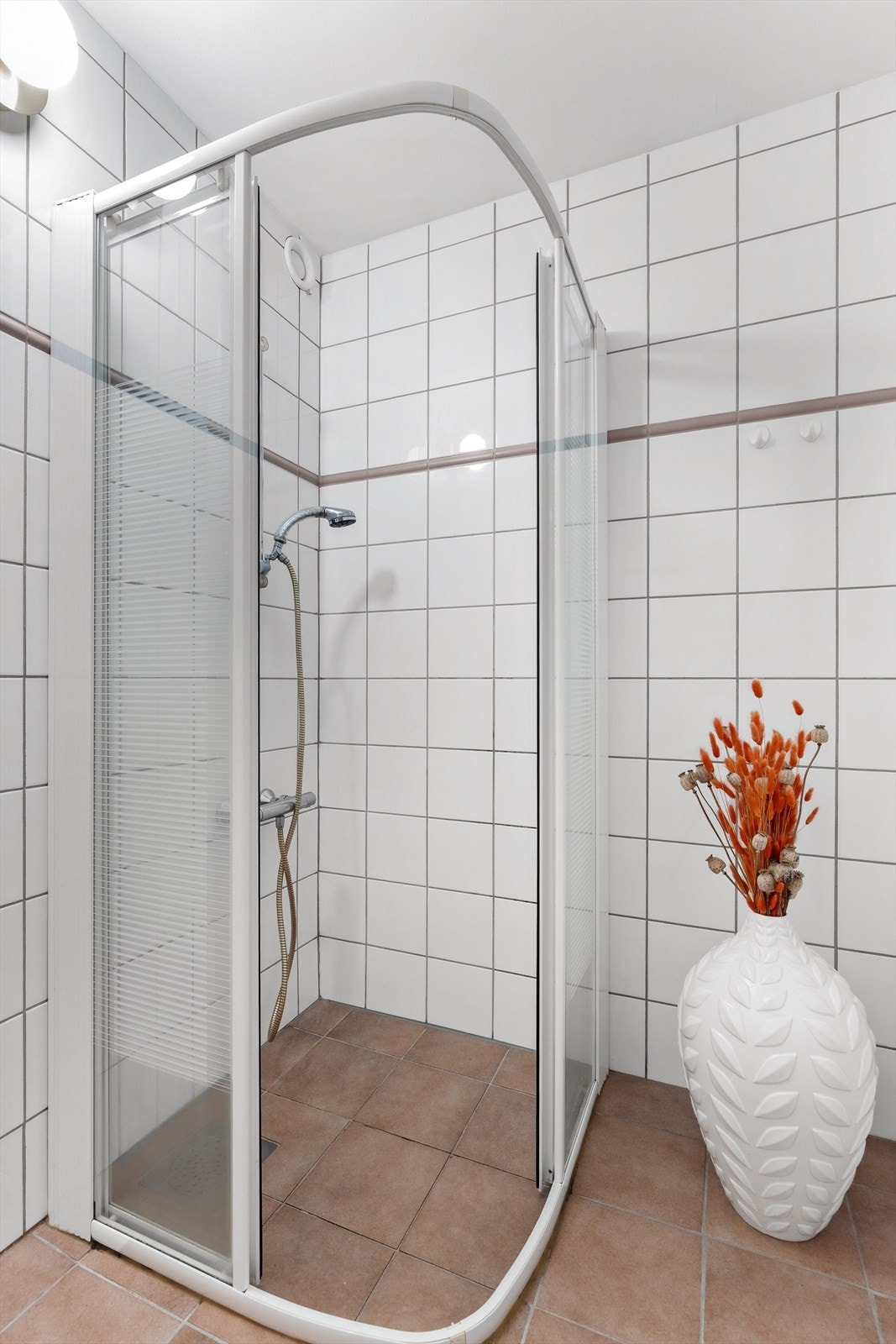 Dusjen er plassert i et separat rom, med dusj på gulv og dusjhjørne med dører. Det er mekanisk avtrekk på badet. Galleribilde
