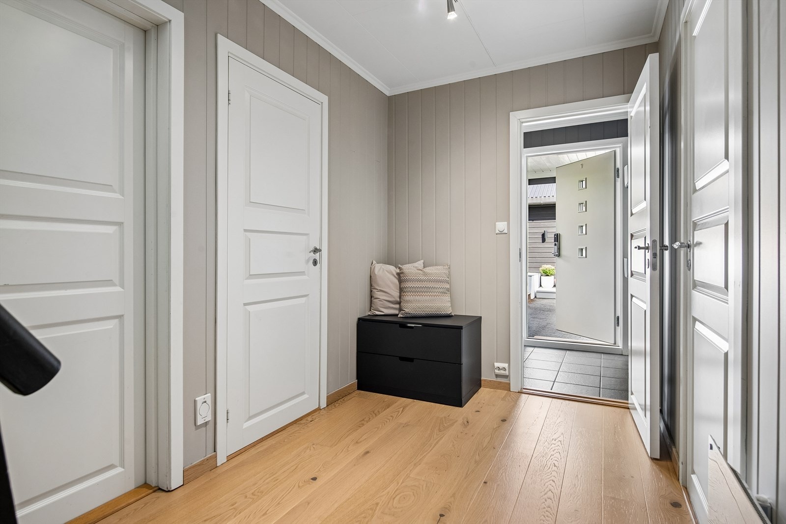 Entréen i underetasjen ønsker velkommen med parkett og panelplater på vegg. Galleribilde