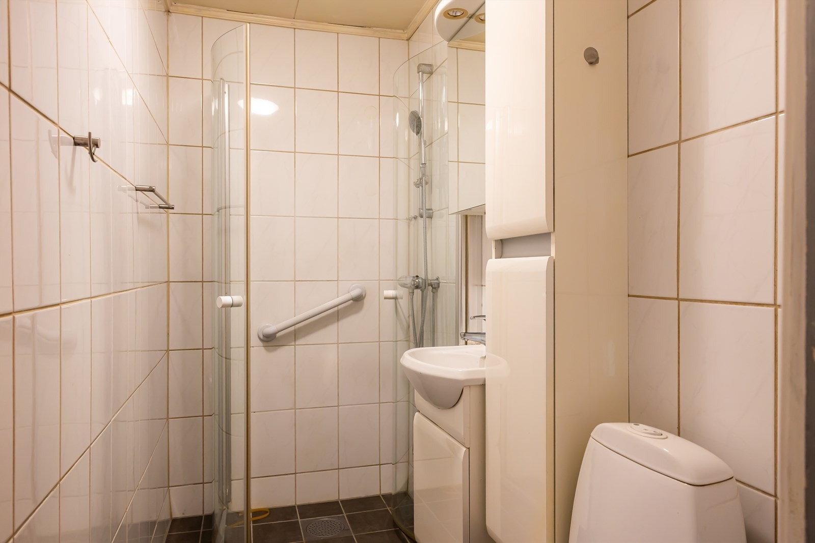 Badet er utstyrt med servant med skap, toalett og elektrisk avtrekksvifte. Galleribilde