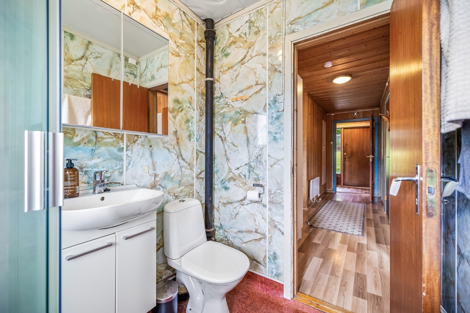 Badet har baderomsplater på veggene og servant i innredning. Galleribilde