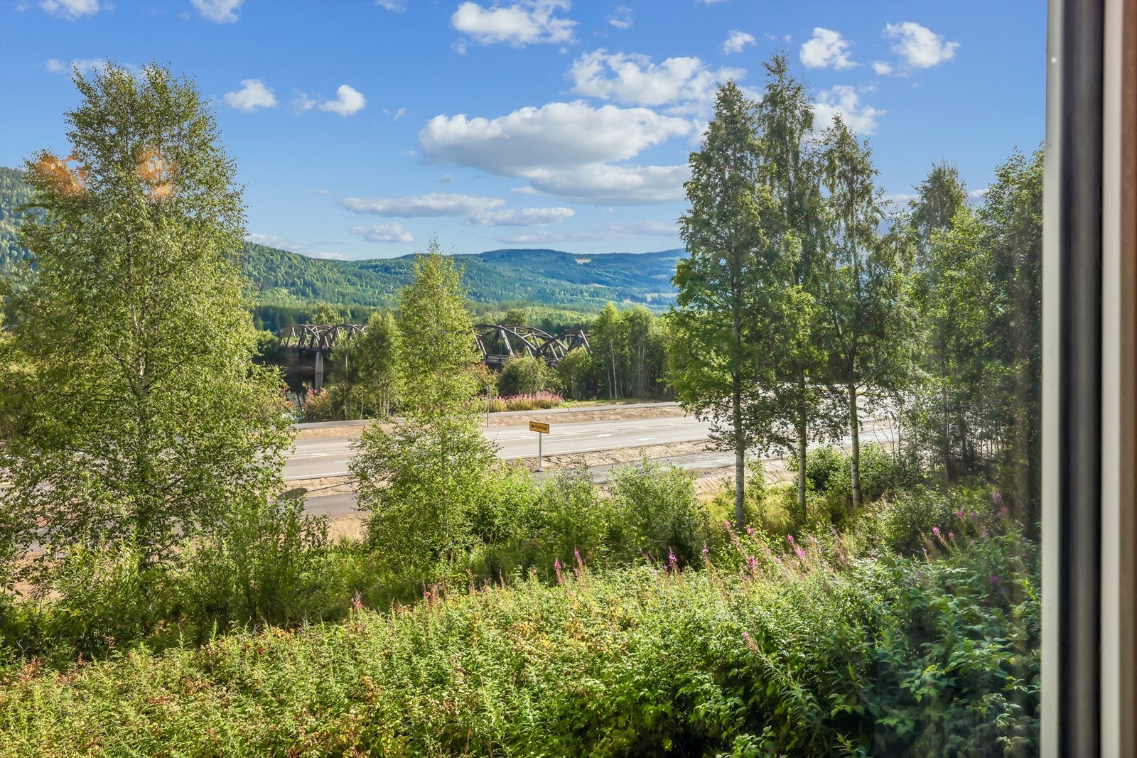 Utsikt fra et av vinduene i første etasje mot elven og landskapet. Galleribilde