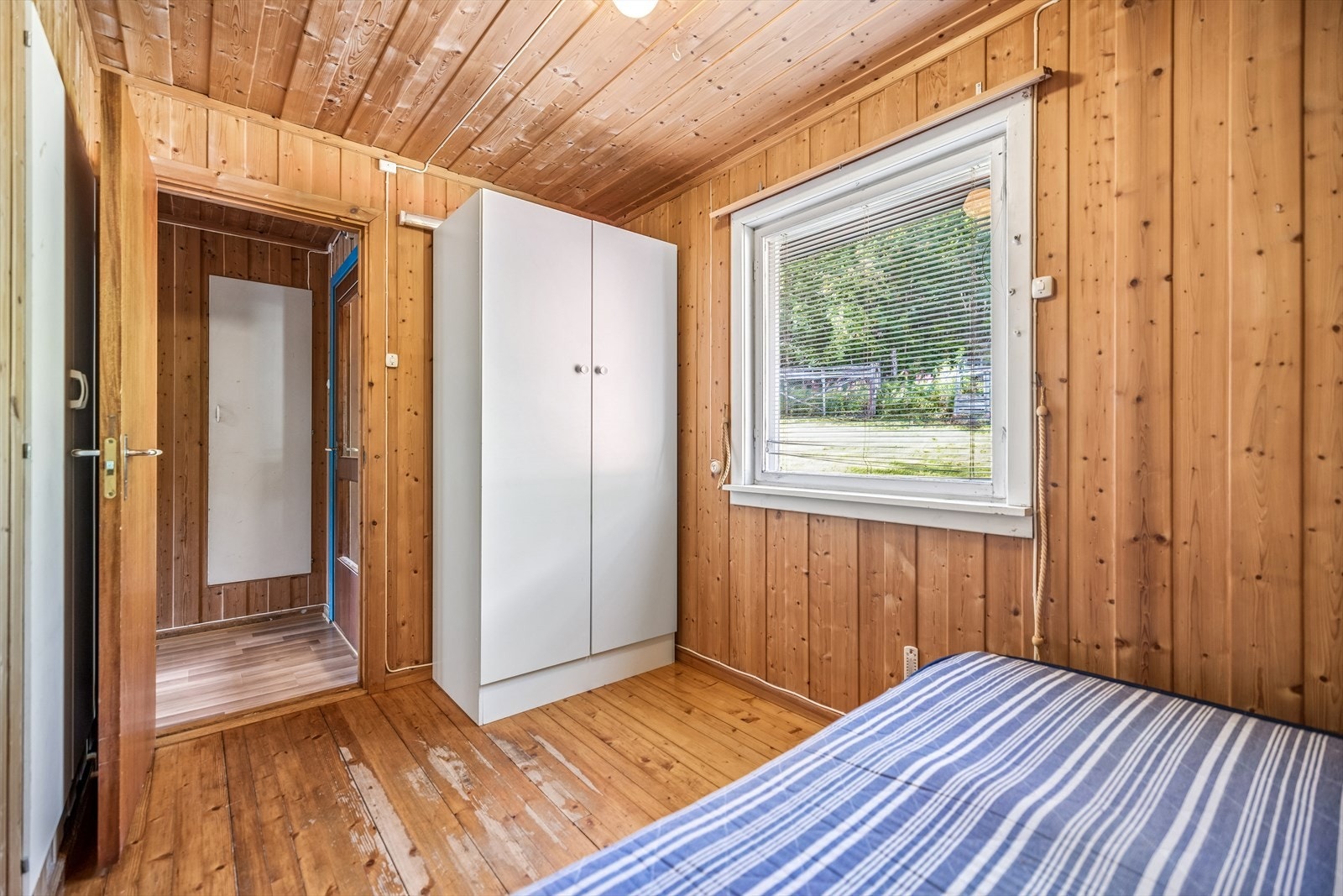 Soverom med lakkert tregulv og plass til garderobeskap. Galleribilde