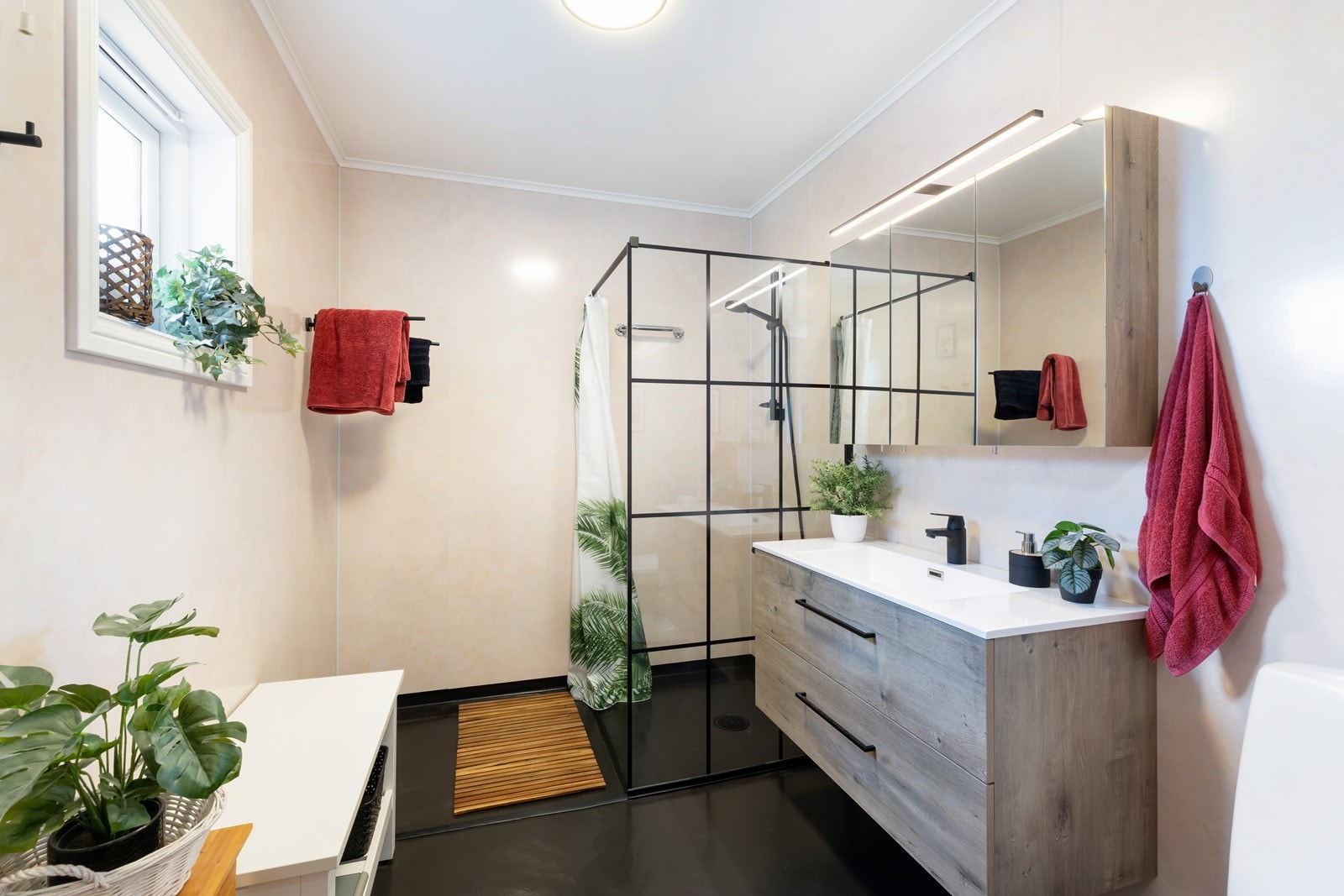 Badet er innredet med dusj, toalett og servant med innredning. Galleribilde