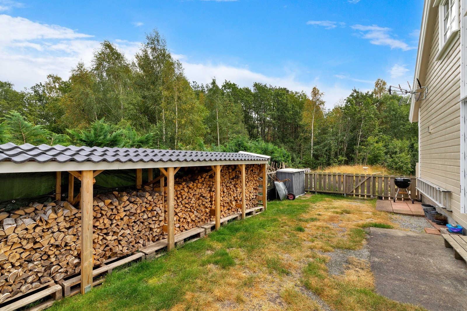 Praktisk vedskjul med kapasitet for lagring av ved til en hel fyringssesong. Galleribilde