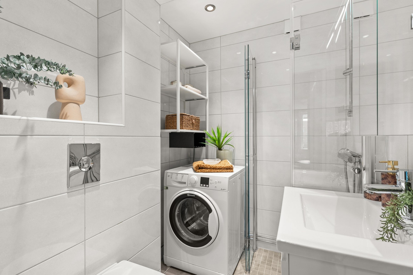 Badet er innredet med vegghengt servantinnredning, heldekkende servant og speilskap med integrert belysning. Dusjhjørne med innfellbare glassdører og vegghengt toalett. Himlingen er nedsenket med downlights som sørger for behagelig belysning. Galleribilde