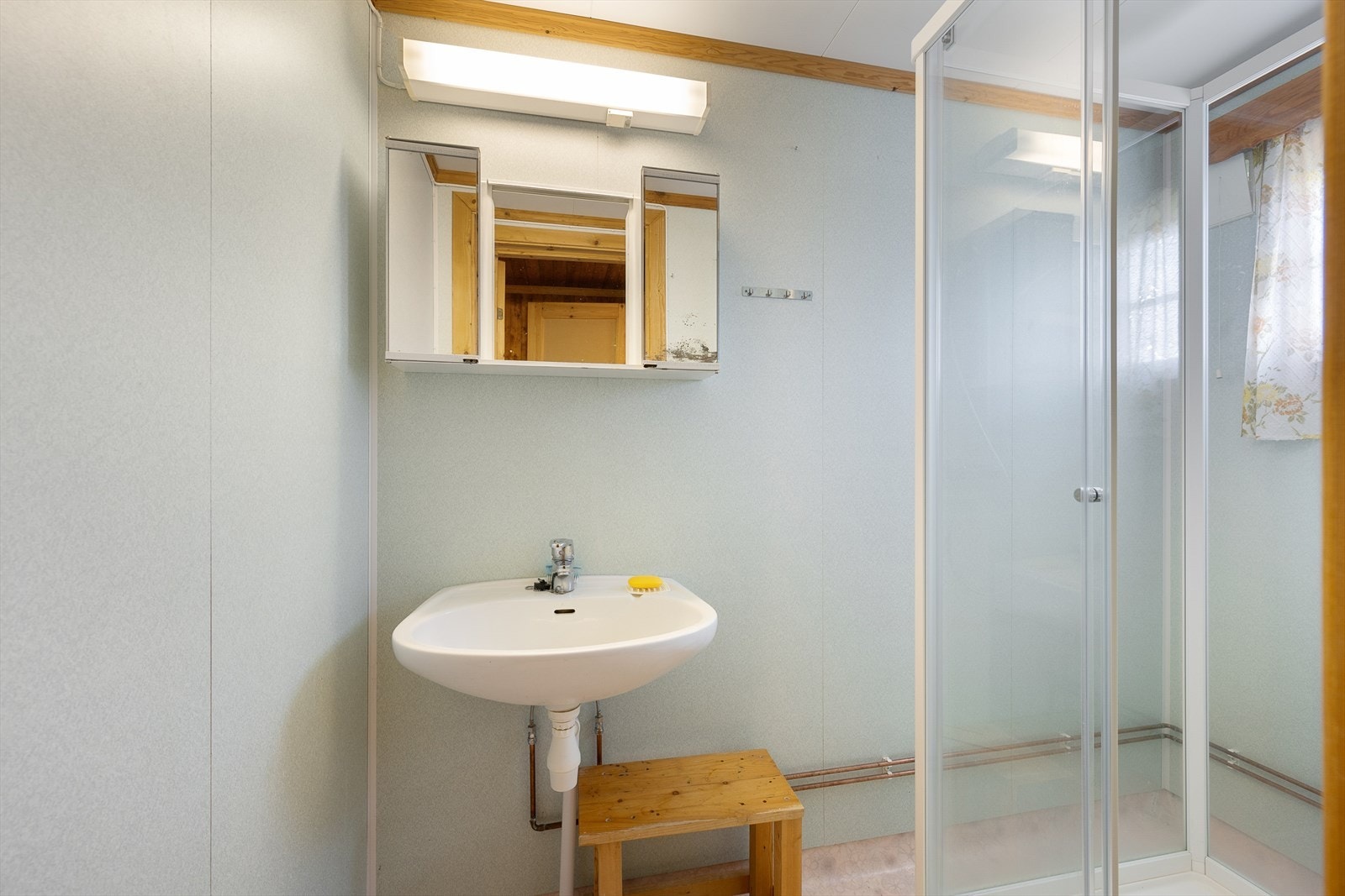 Badet er utstyrt med servant, speilskap og dusjkabinett. Galleribilde