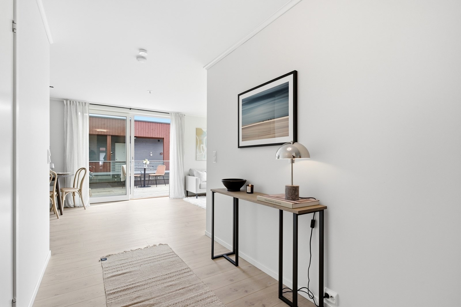 Gangen leder videre inn til leilighetens oppholdsrom med gjennomgående parkett. Galleribilde