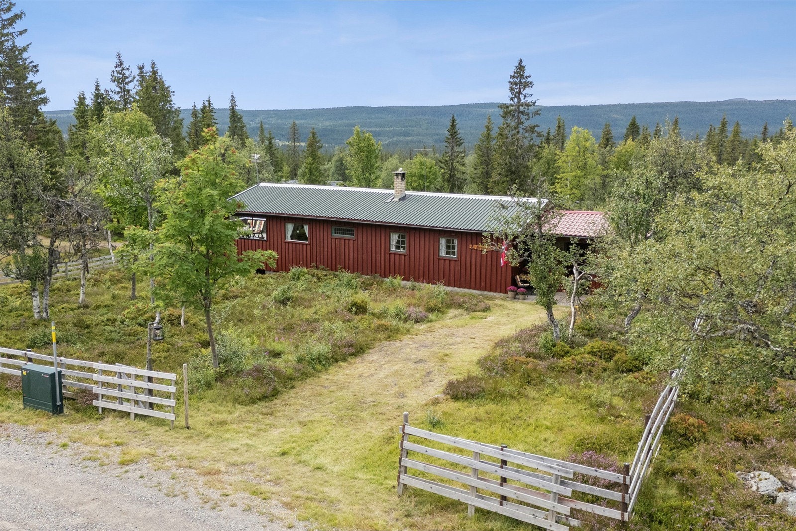 Hyggelig natureiendom med gressvokst innkjøring. Fremsiden av tomta er inngjerdet. Galleribilde