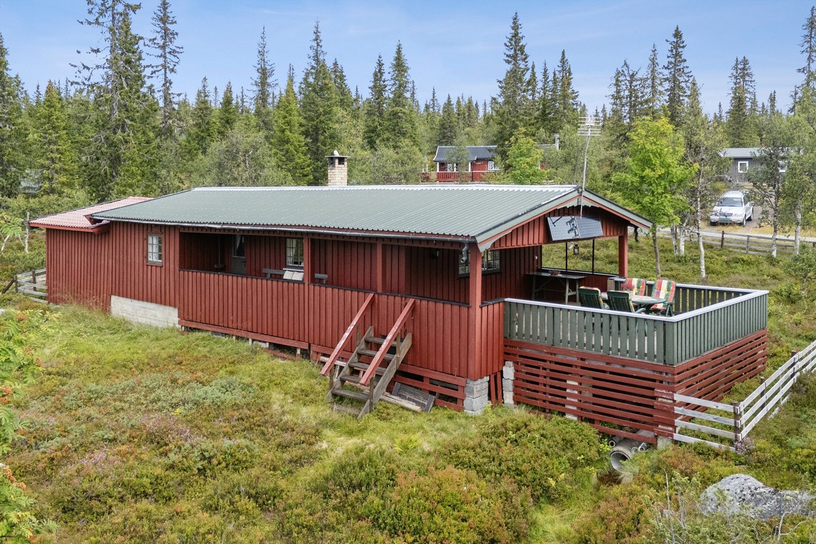 Fasade mot vest. Stor solrik terrasse som er delvis overbygd. Trapp ned til terreng. Galleribilde