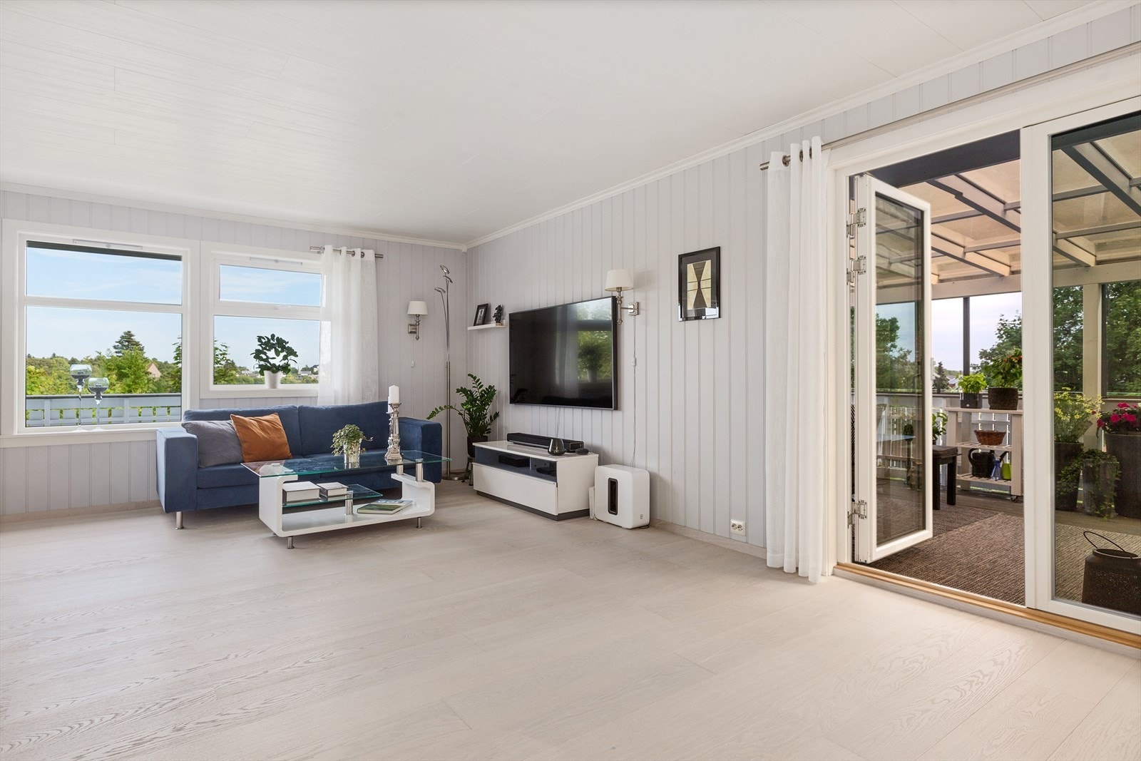 Verandadør med glassfelt fra 2019 åpner opp mot den innglassede uteplassen. Galleribilde