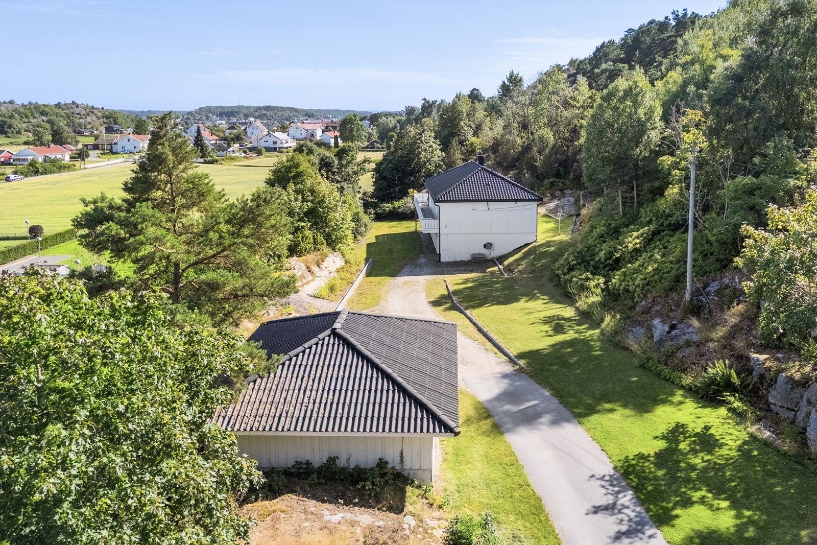 Oversikt over eiendommen med bolighus og garasje. Galleribilde