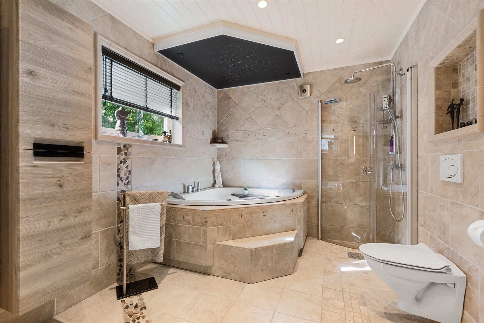Badet er utstyrt med både massasjebad og dusjløsning, samt vegghengt toalett. Tak med stjernehimmel i fiber ledlys. Galleribilde