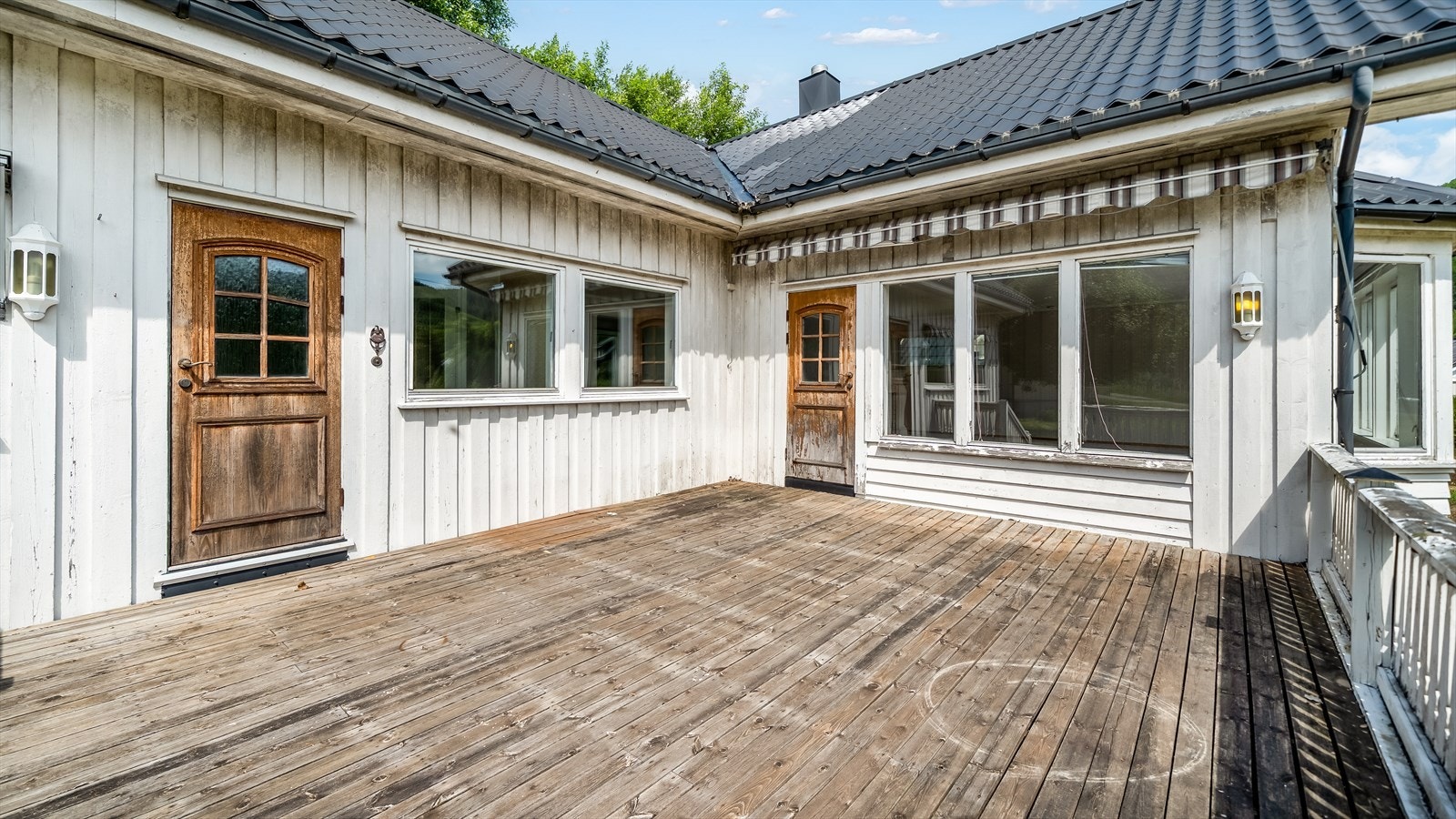 Stor terrasse i front av boligen med adkomst til gang og stue. Galleribilde