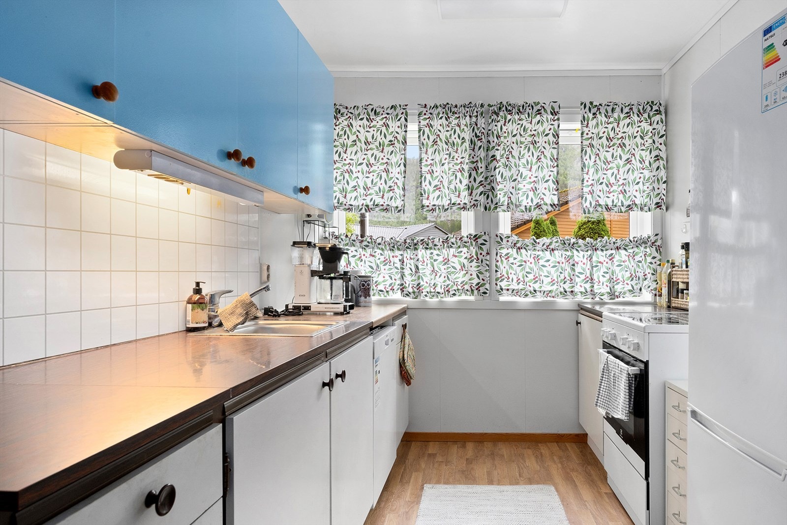 Kjøkkenet har innredning med glatte malte fronter samt benkeplate av laminat med nedfelt vask av stål. Galleribilde