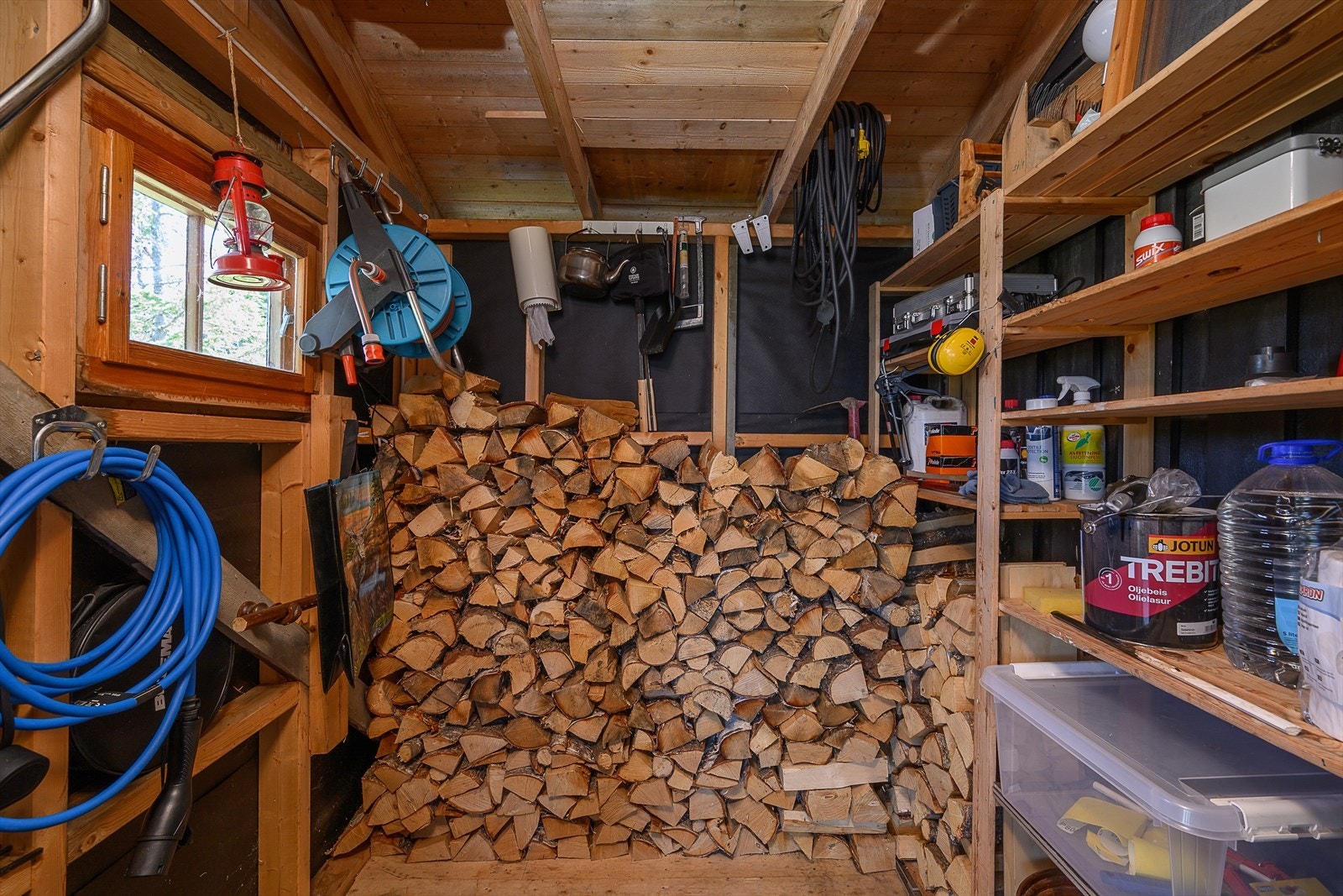 Innvendig bod med god lagringsplass for ved og utstyr. Galleribilde