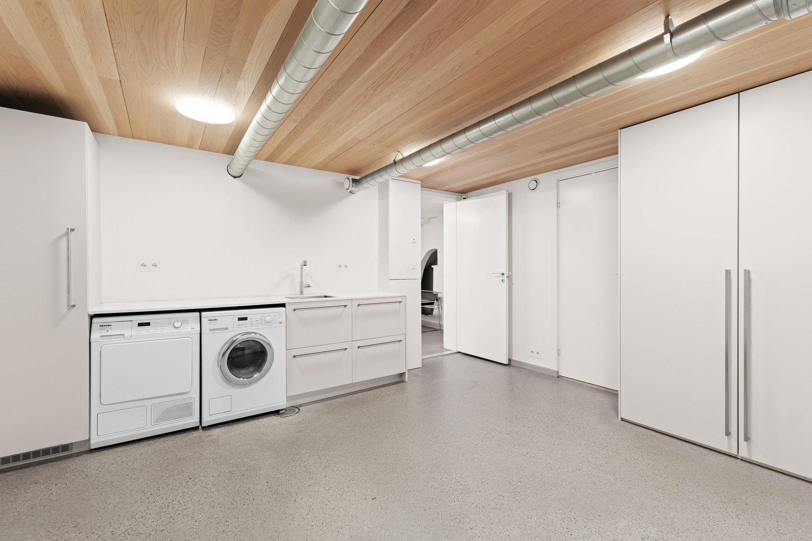 Romslig vaskerom med solide installasjoner og god lagringsplass i kjelleretasje. Galleribilde