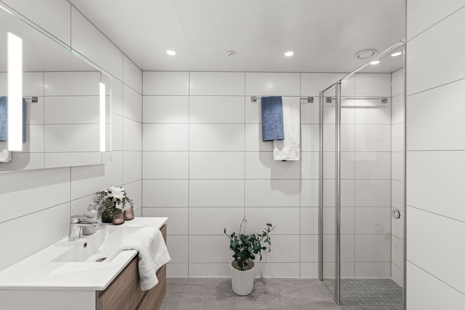 Badet er fra byggeår og har flislagte overflater med 30x30-fliser på gulv, 5x5-fliser i dusjnisje og 30x60-fliser på vegger. Galleribilde