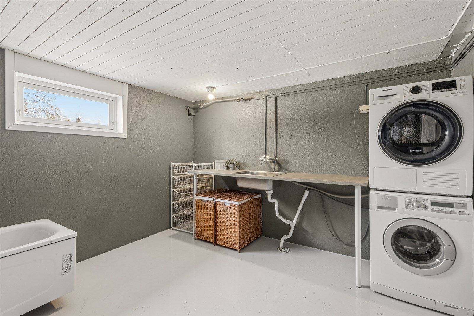 Praktisk og romslig vaskerom i kjelleren med opplegg for vaskemaskin og tørketrommel. Galleribilde