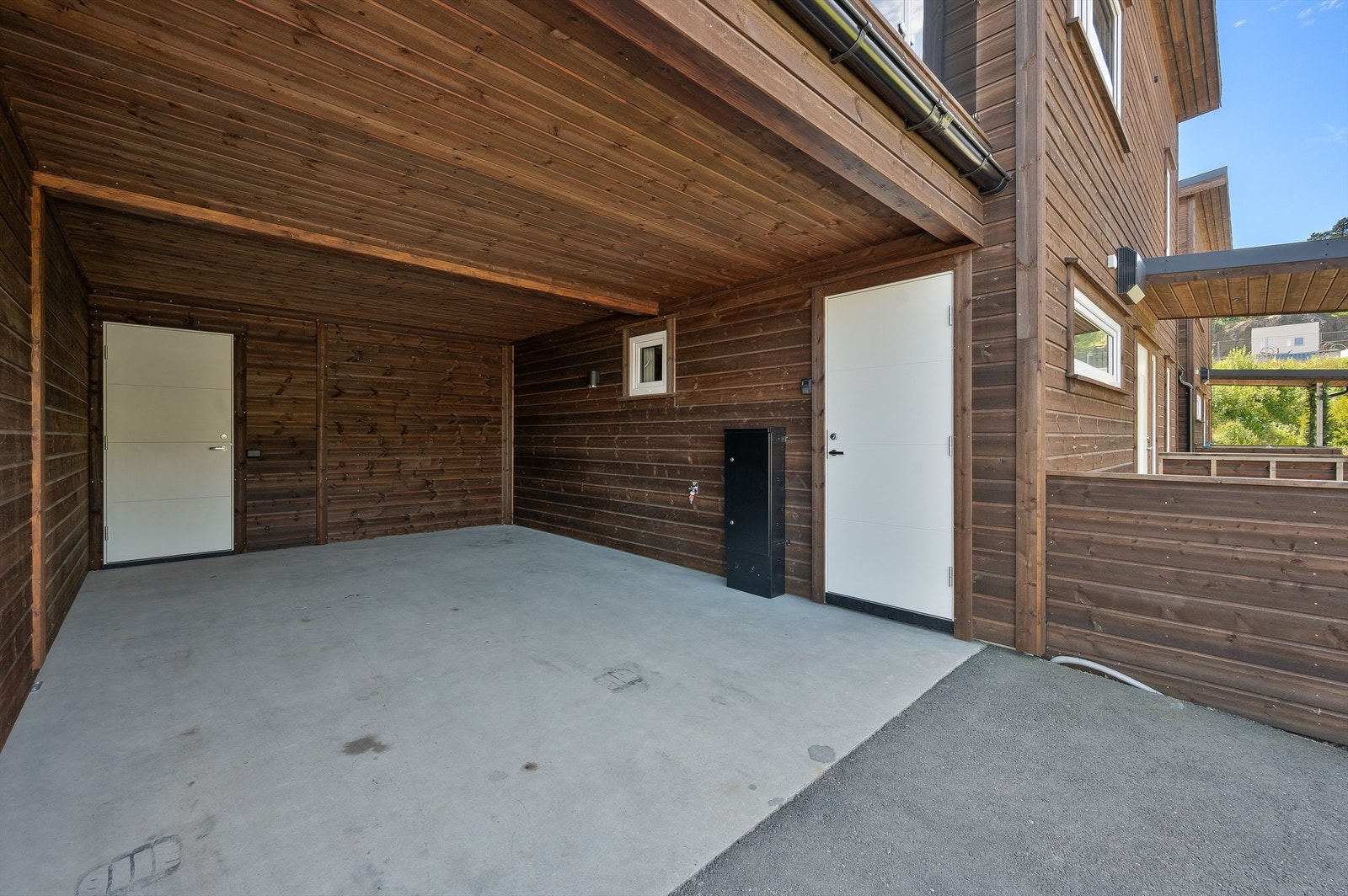 Carport med bod på innsiden. Den andre døren er direkte adkomst til vaskerommet. Galleribilde