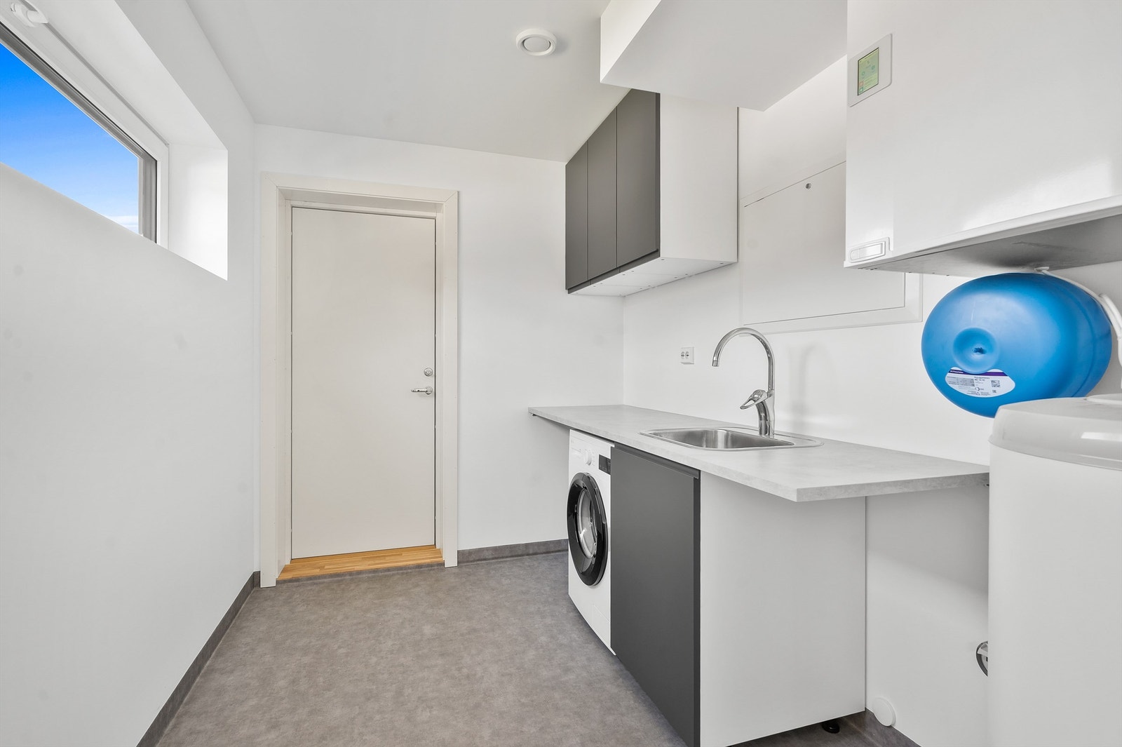 Separat vaskerom/teknisk rom med praktisk benk, skapplass og direkte utgang til carport. Galleribilde