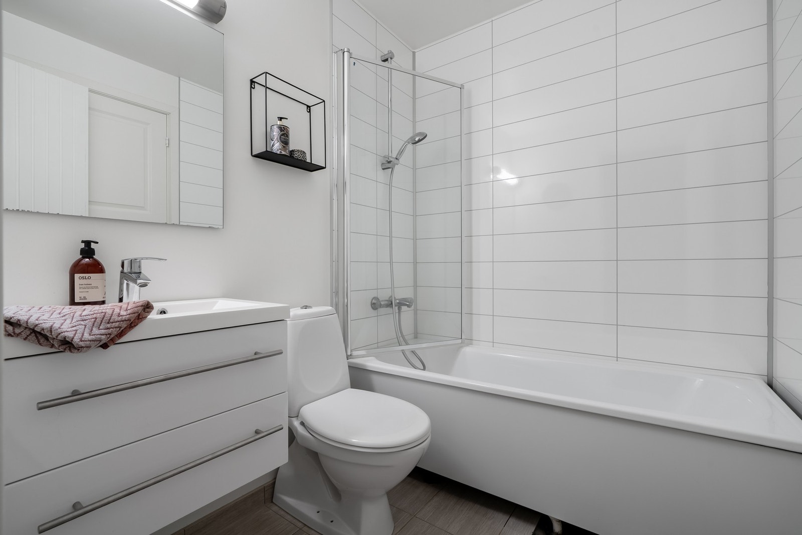 Pent bad med lyse overflater, badekar og moderne innredning. Galleribilde