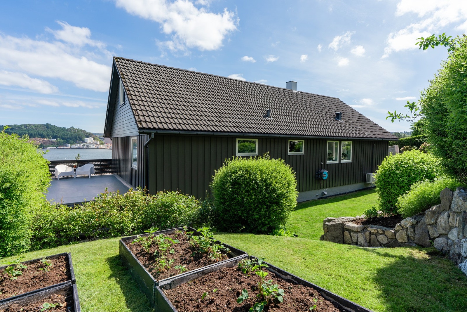 Velstelt hage med plen og praktiske plantekasser for den hageinteresserte. Galleribilde