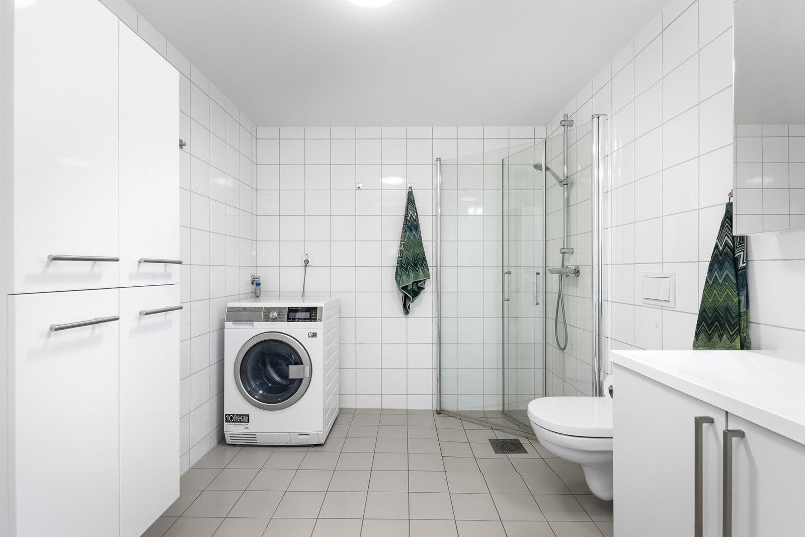 Romslig bad med plass til både vaskemaskin og tørketrommel. Galleribilde
