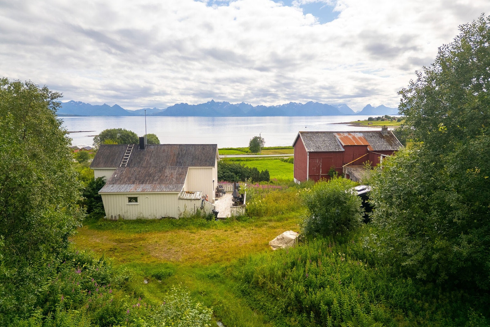Oversikt over gårdstunet med våningshus og driftsbygning. Galleribilde