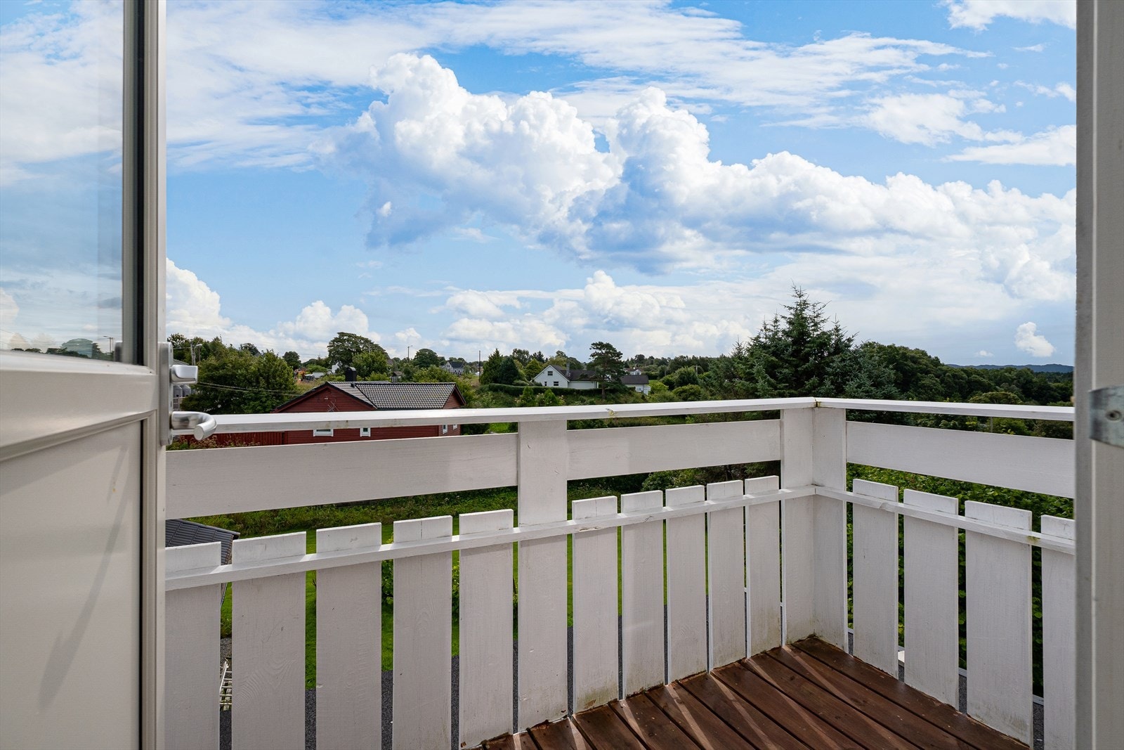 Balkongen måler ca 3,6m² med rekkverk og terrassebord i trevirke. Galleribilde
