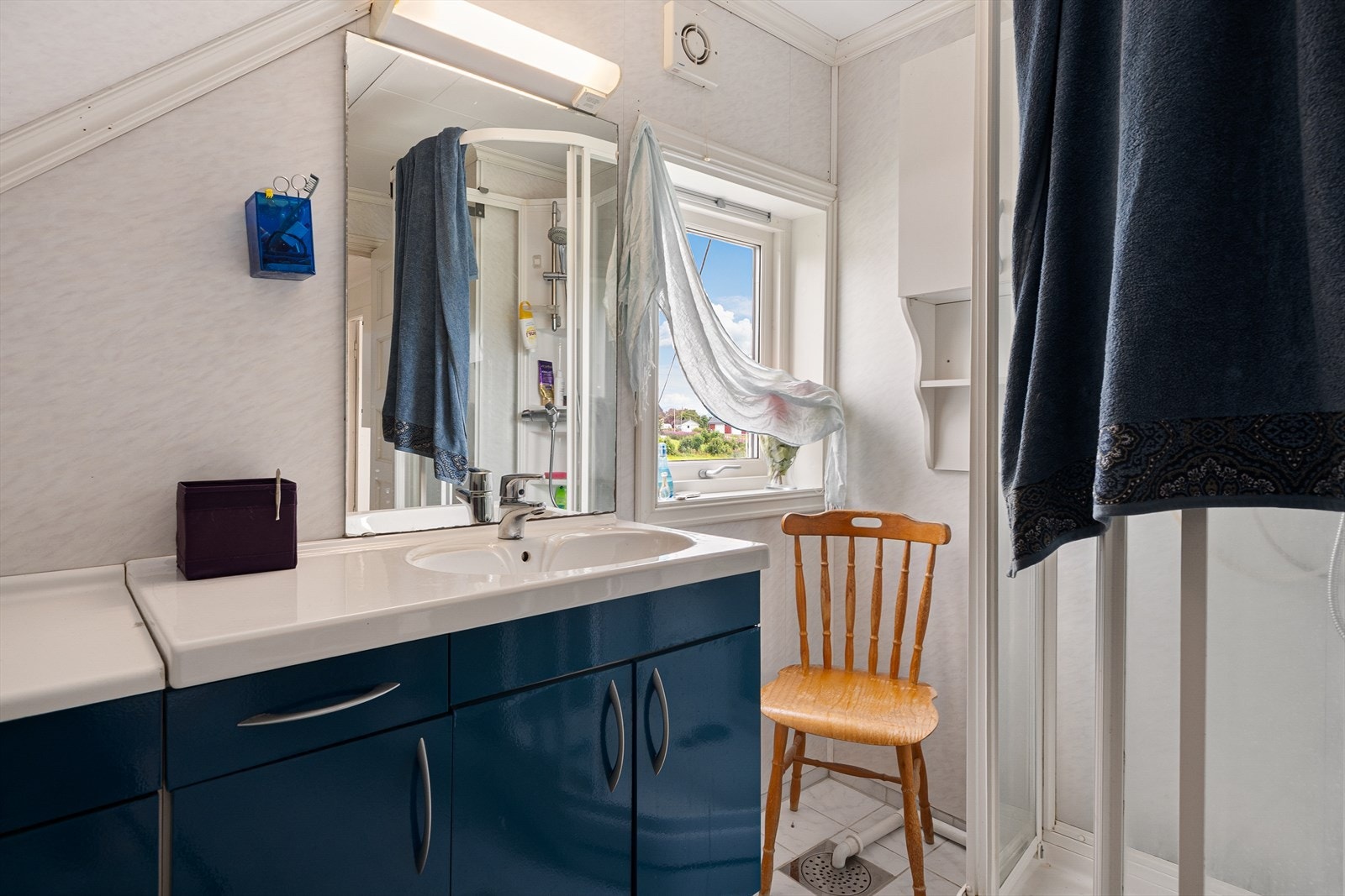 Badet byr på dusjkabinett, toalett, speil og benkeskap med servant som gir gode oppbevaringsmuligheter. Galleribilde