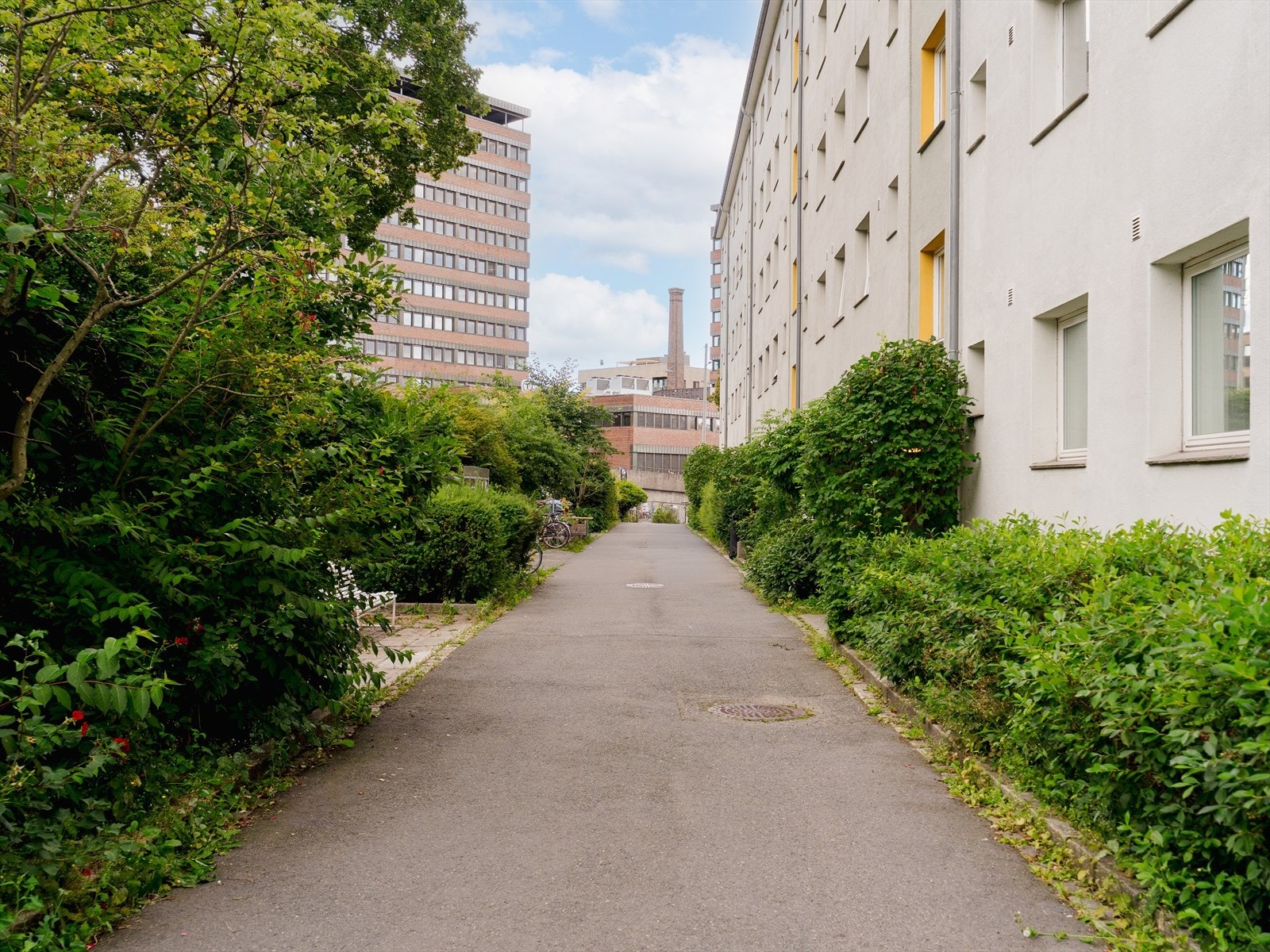 Inngangspartiet ligger skjermet til i frodige omgivelser. Rett utenfor døren finner du sykkelstativ, og med kun ett minutts gange til T-banen er det enkelt å komme seg rundt. Galleribilde