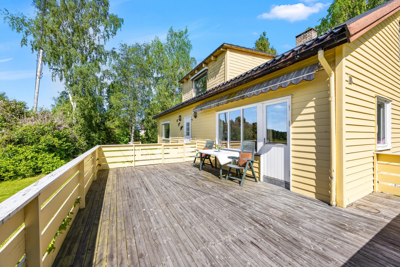 Terrassen vender mot jordet og har en åpen og fin beliggenhet med hyggelig utsyn over de grønne omgivelsene. Galleribilde